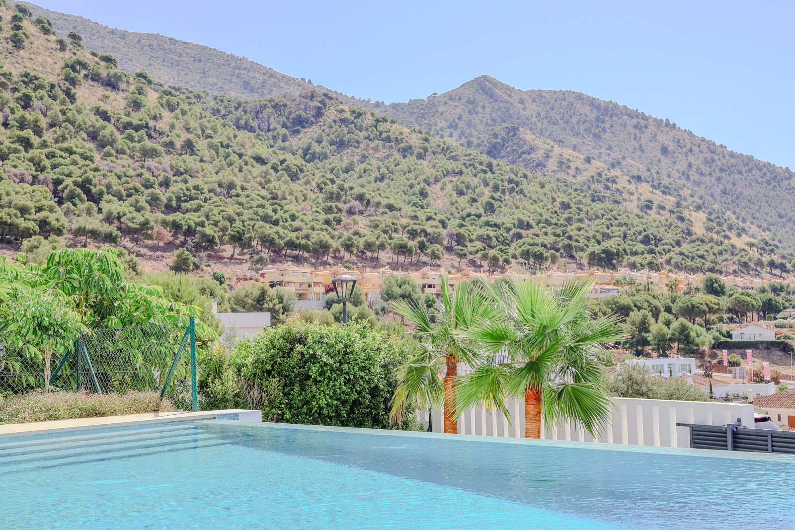 Infinity pool edge overlooking a scenic mountain view.