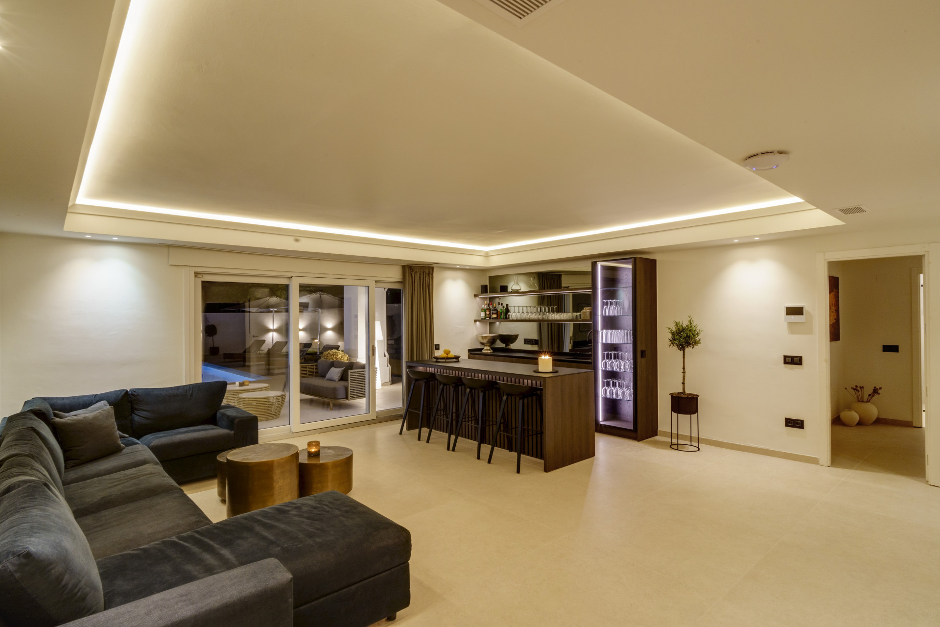 Living room featuring a sectional sofa, wet bar, and sliding doors to outdoor seating area.