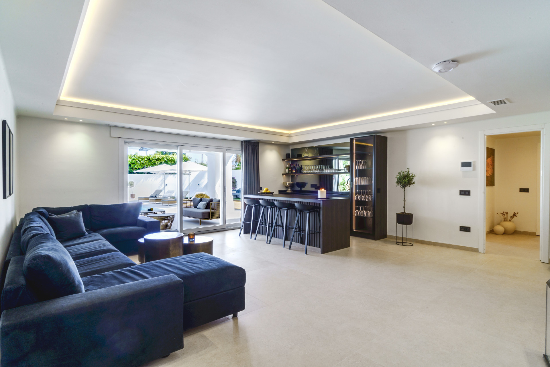 Spacious living area featuring a sectional sofa, bar area, and sliding doors to outdoor space.