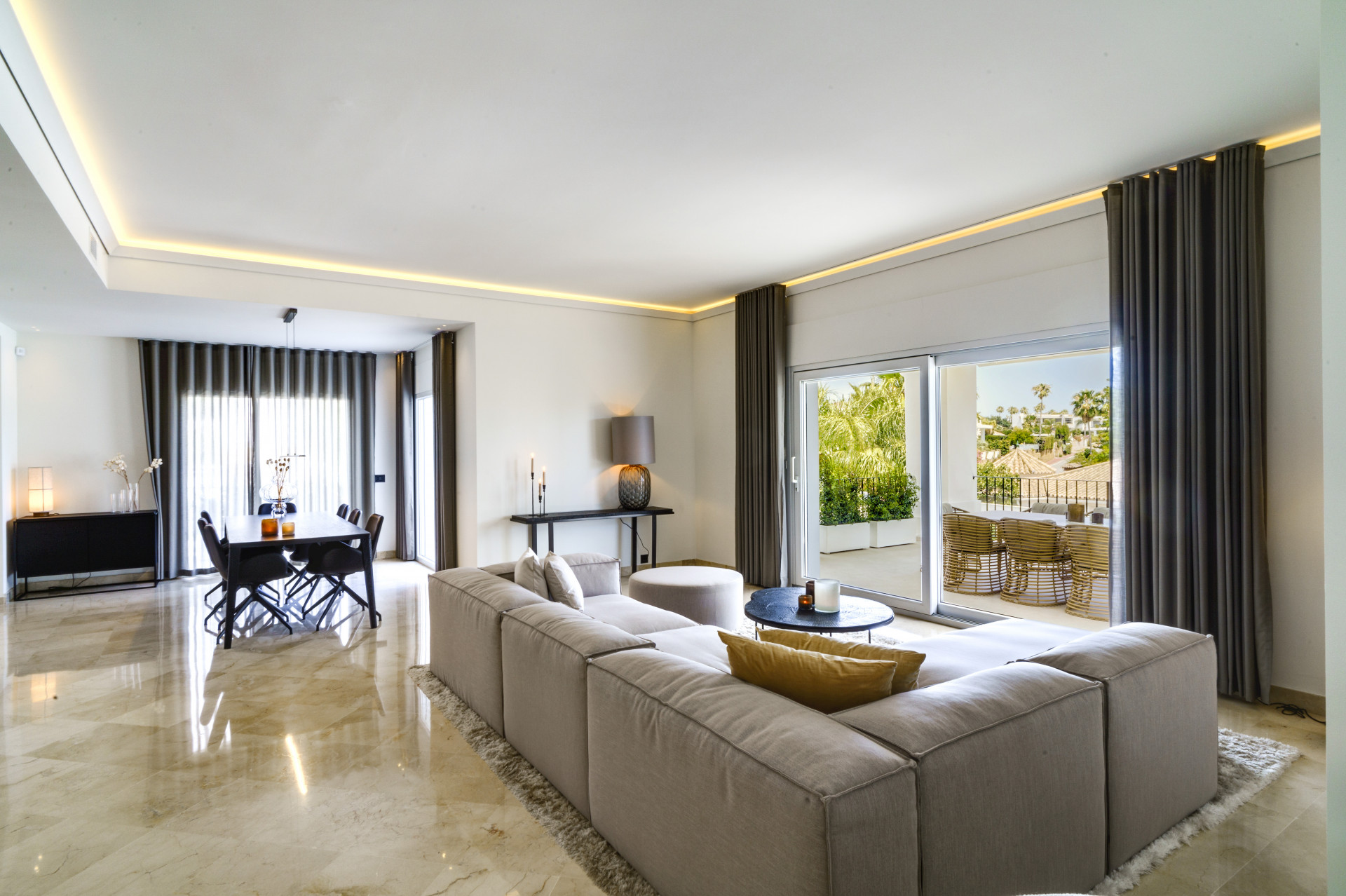 Living room with comfortable seating, dining area in view, and access to the outdoor terrace.