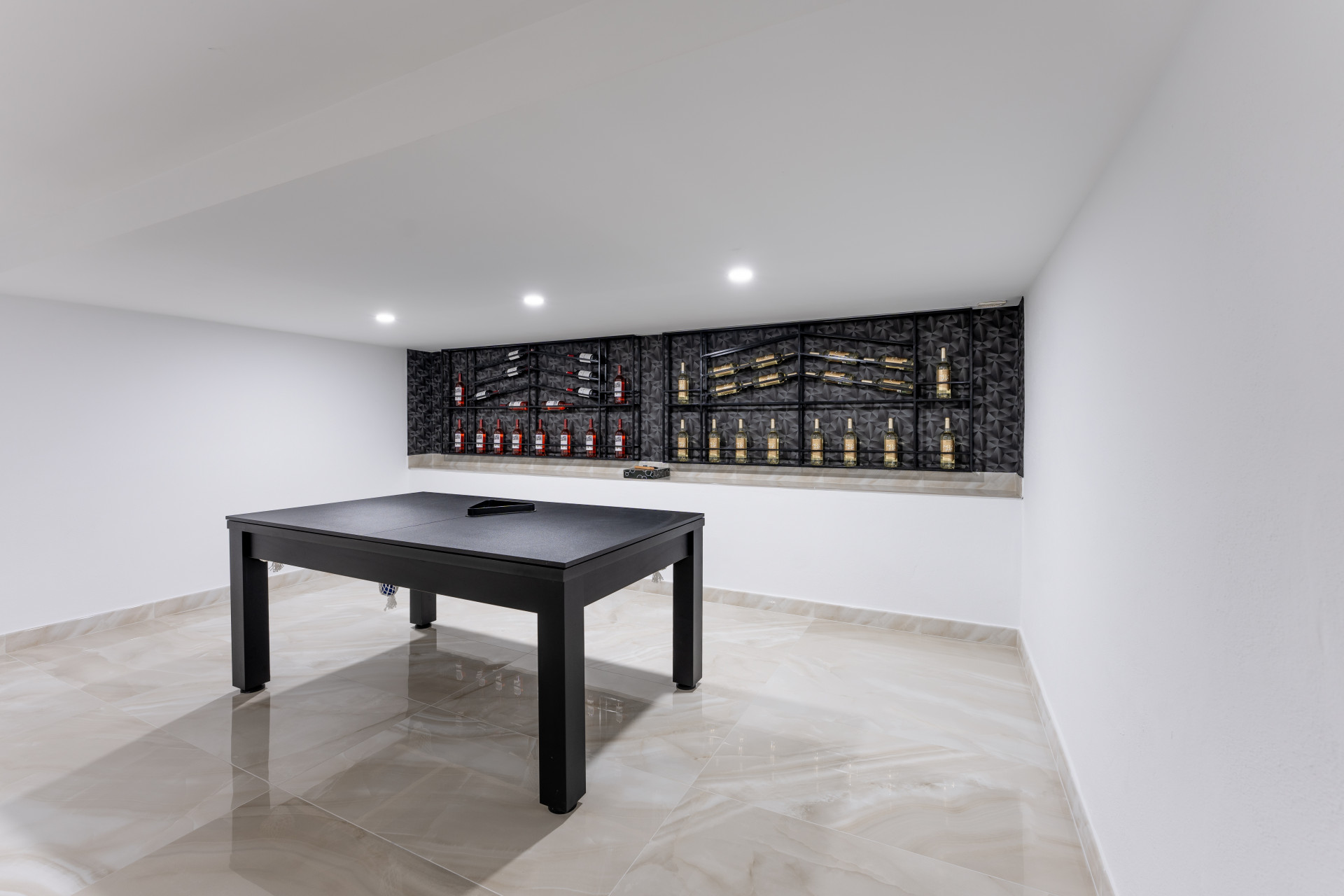 Close up of the black pool table in the media room, with decorative wine racks on the wall.