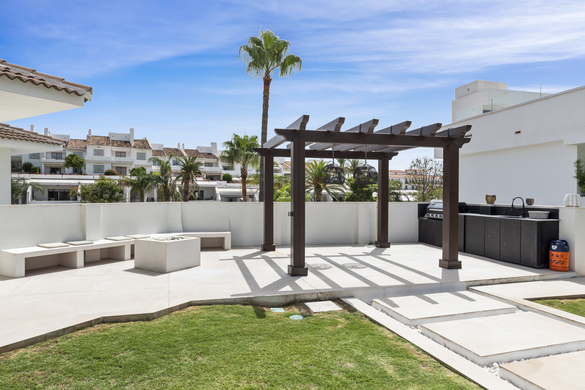 Outdoor space featuring a shaded pergola and BBQ area.
