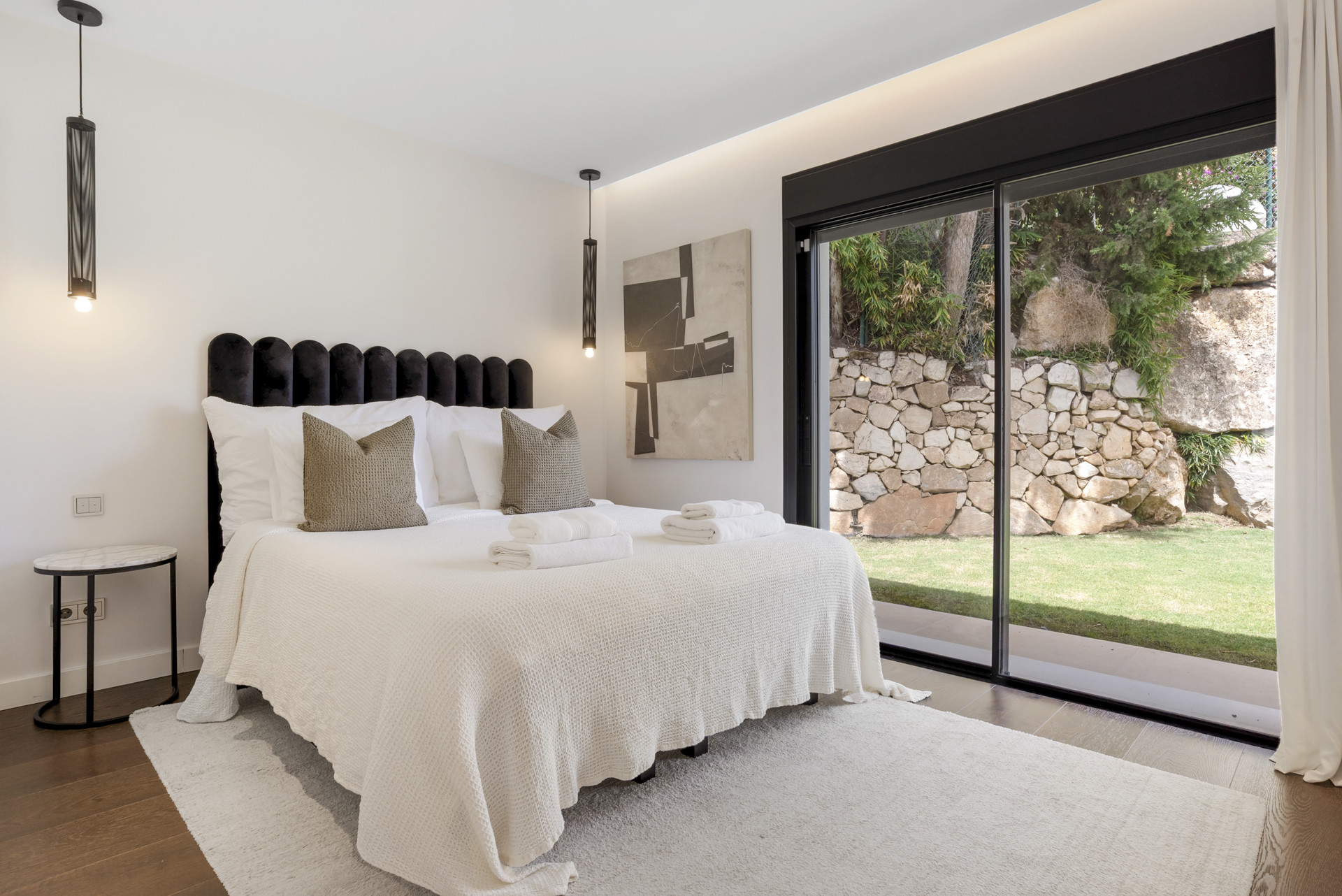 Cozy bedroom featuring a bed with decorative pillows and sliding glass doors.