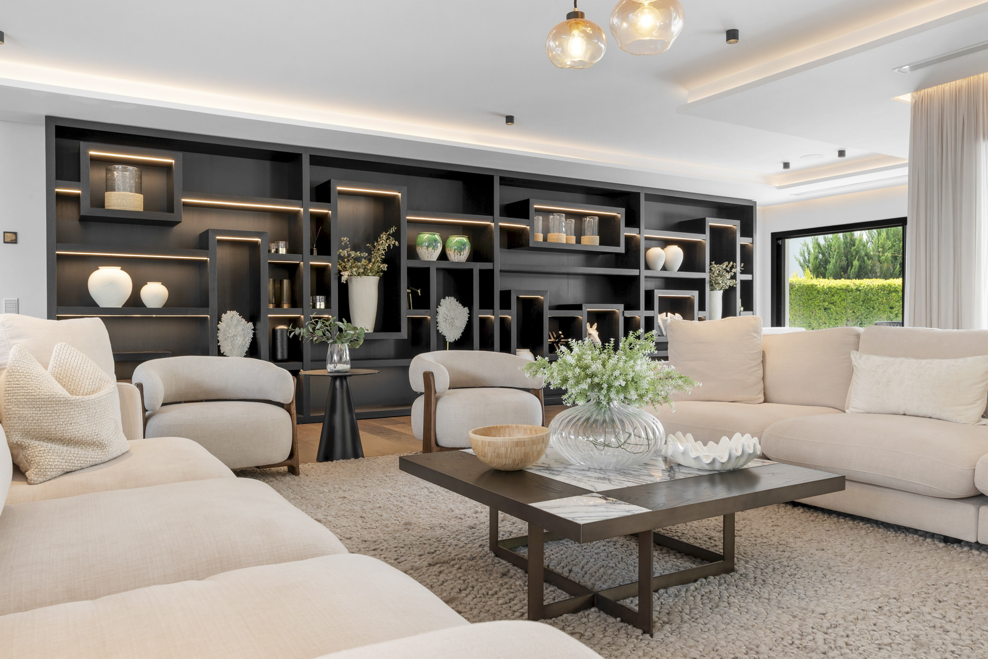 Stylish lounge space showcasing a modern black shelving unit and comfortable seating.