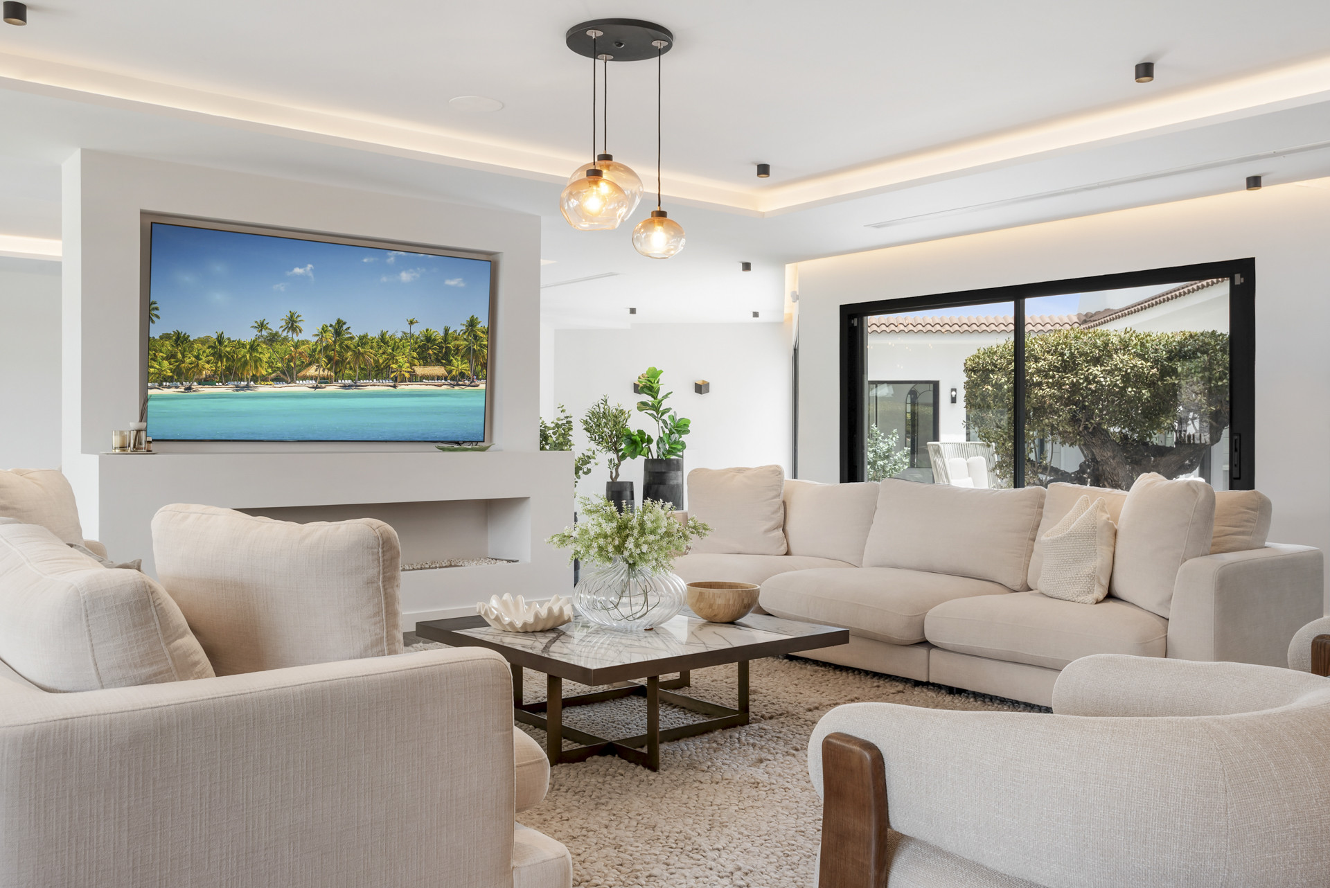 Elegant living area with a TV wall and modern decor, overlooking the outdoor space.