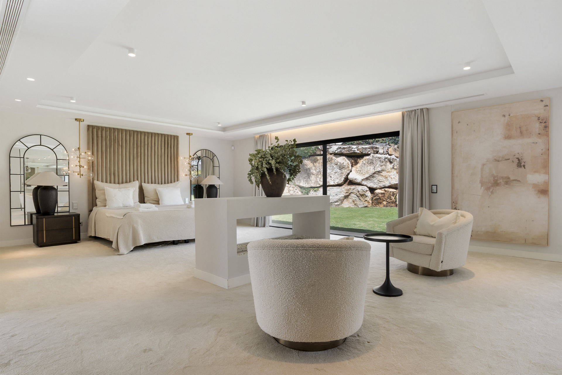 Spacious master bedroom features a large bed, elegant decor, and floor-to-ceiling windows to the garden.