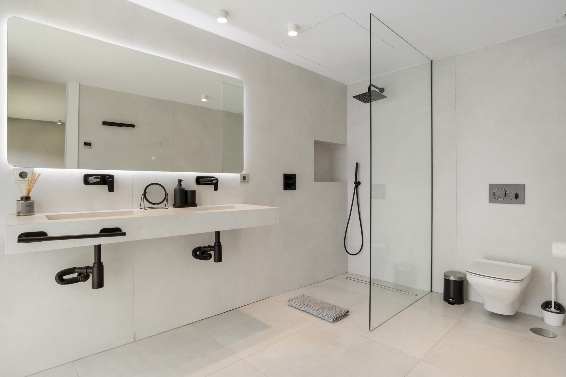 Modern bathroom with a floating sink, large mirror, and walk-in shower.