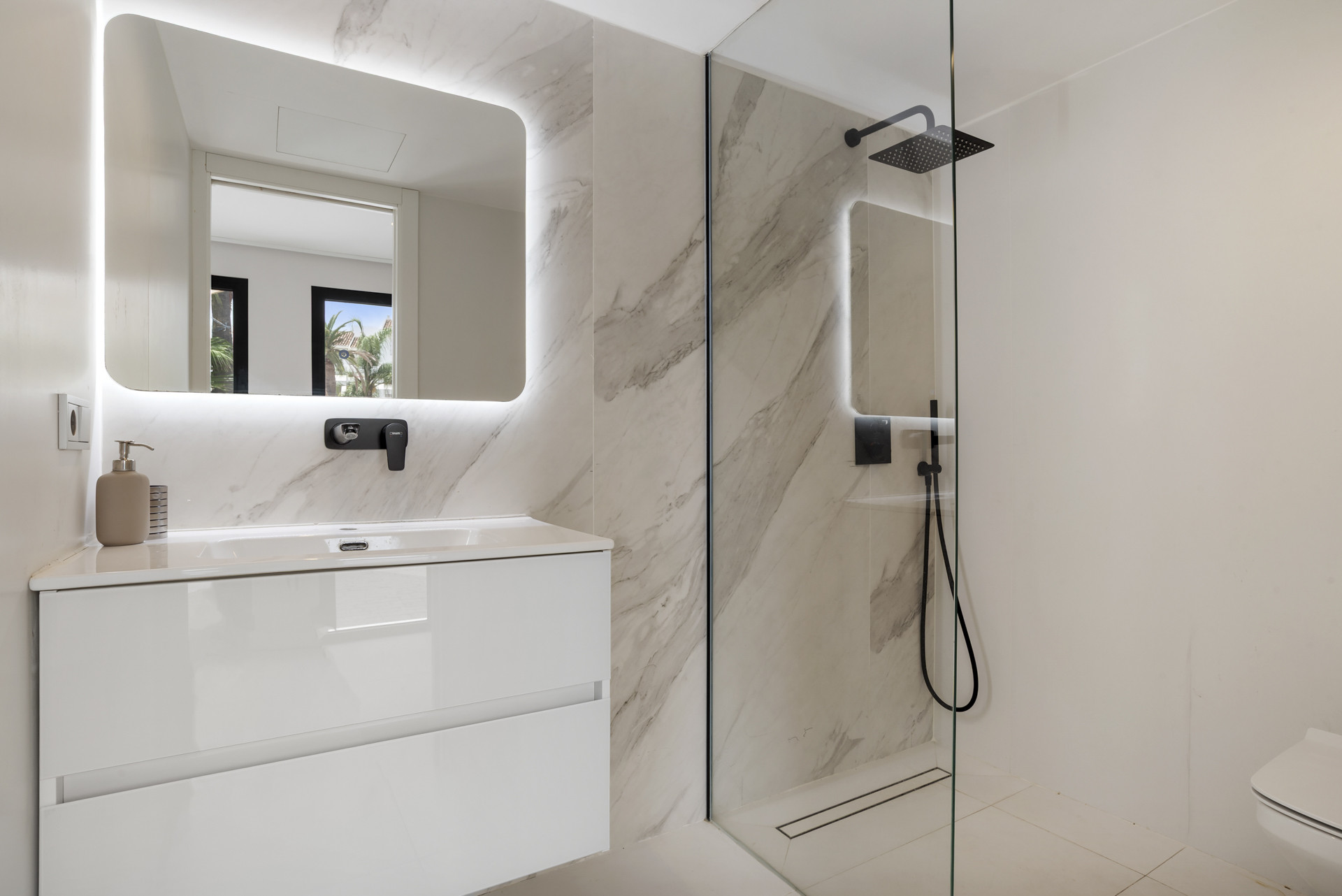 Contemporary bathroom with a stylish shower and illuminated mirror.