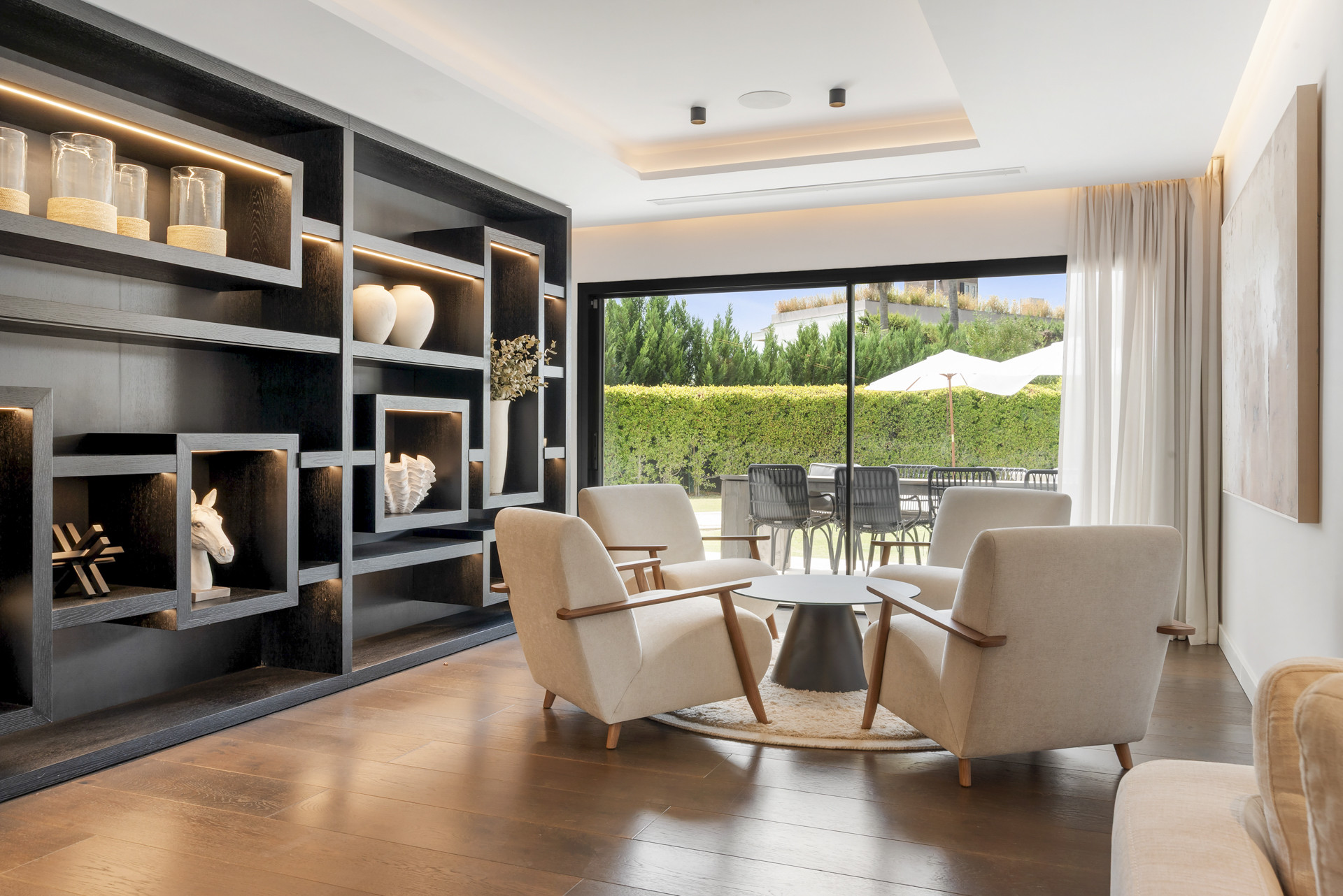 Cozy seating area featuring a black shelving unit and views to the garden.