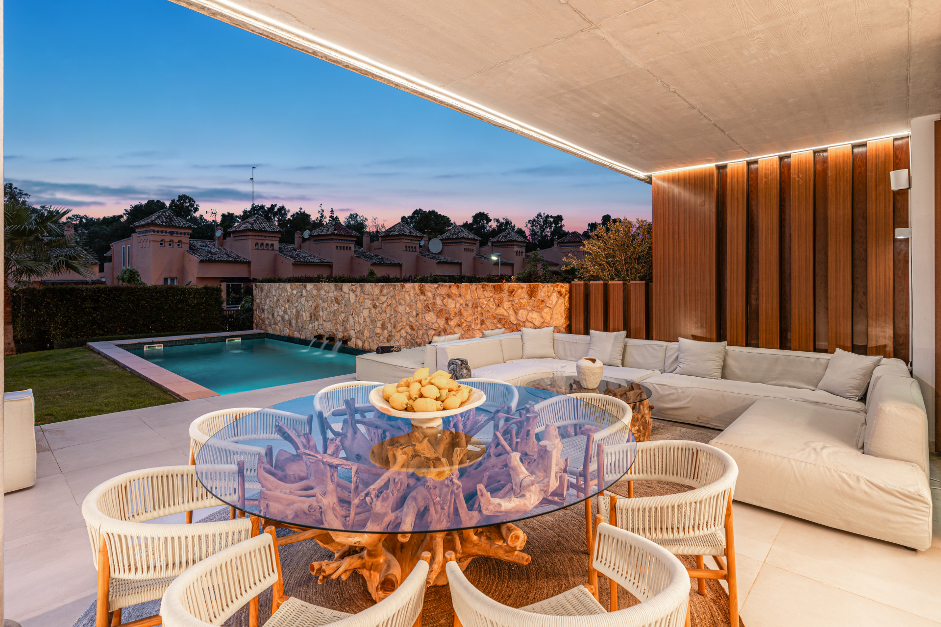 Patio with a view of the pool and surrounding greenery at twilight.