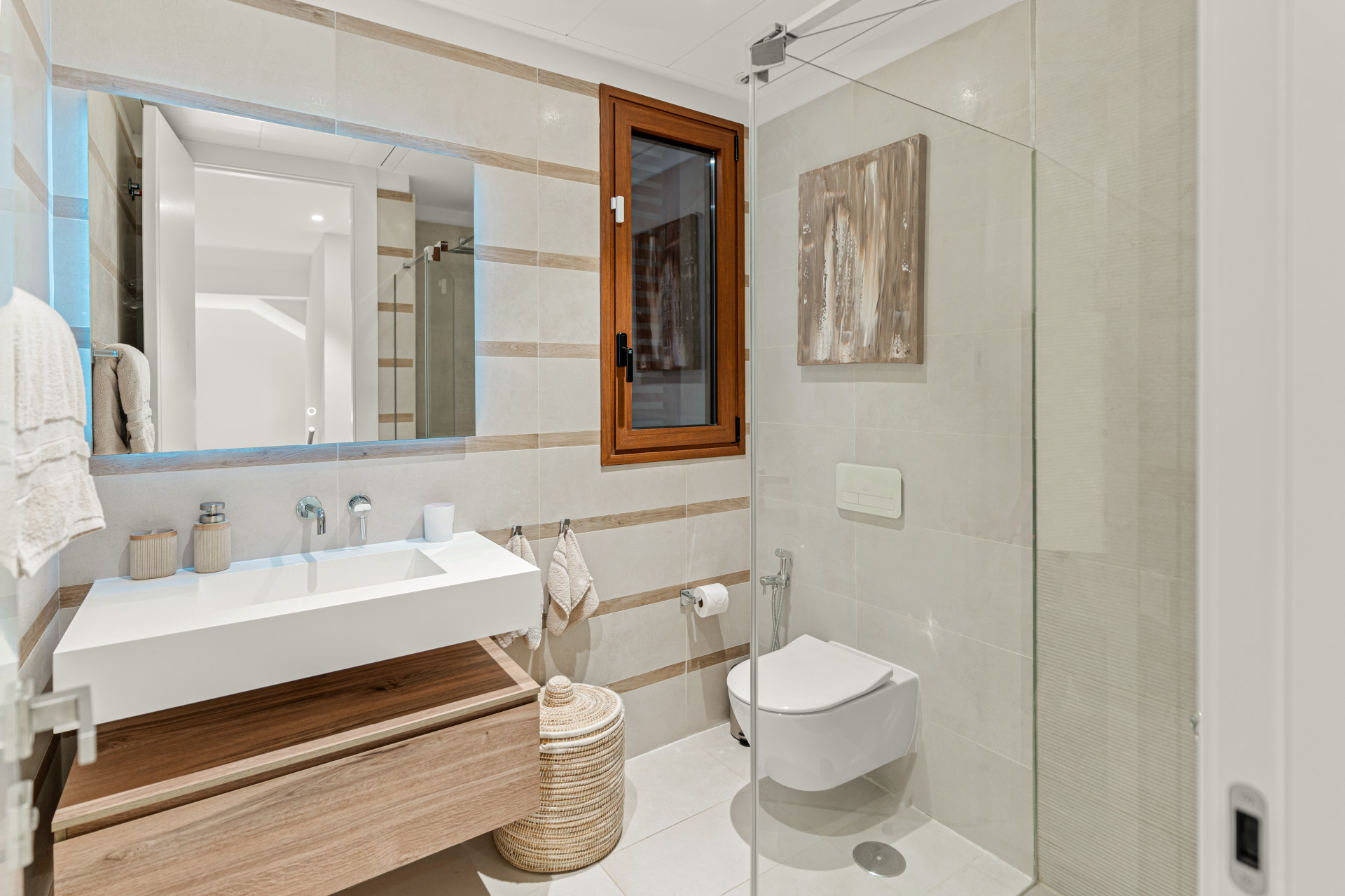 Modern bathroom with a white sink, wood accents, and a glass shower enclosure.