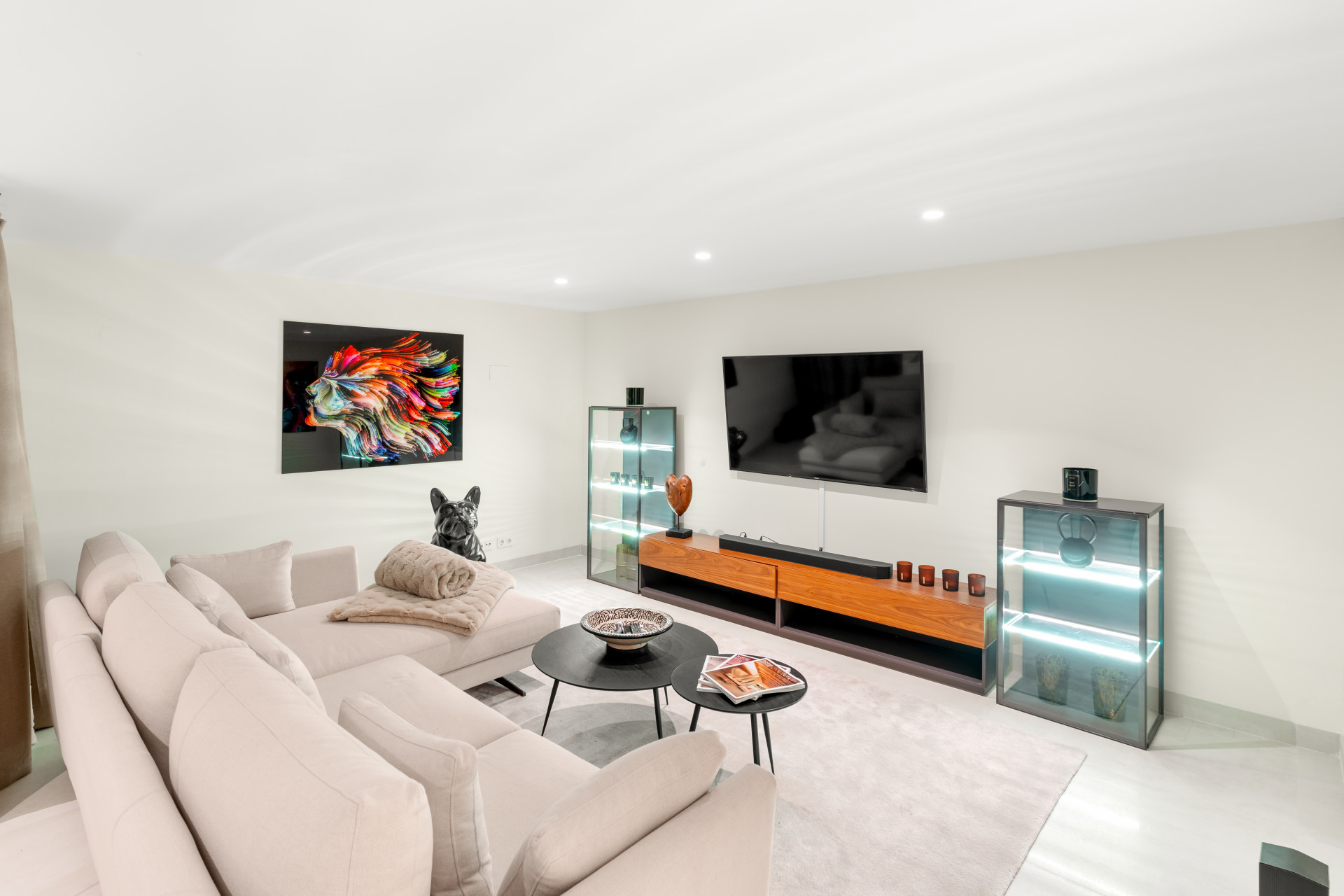 Cozy living room with plush seating, large TV, and decorative artwork.