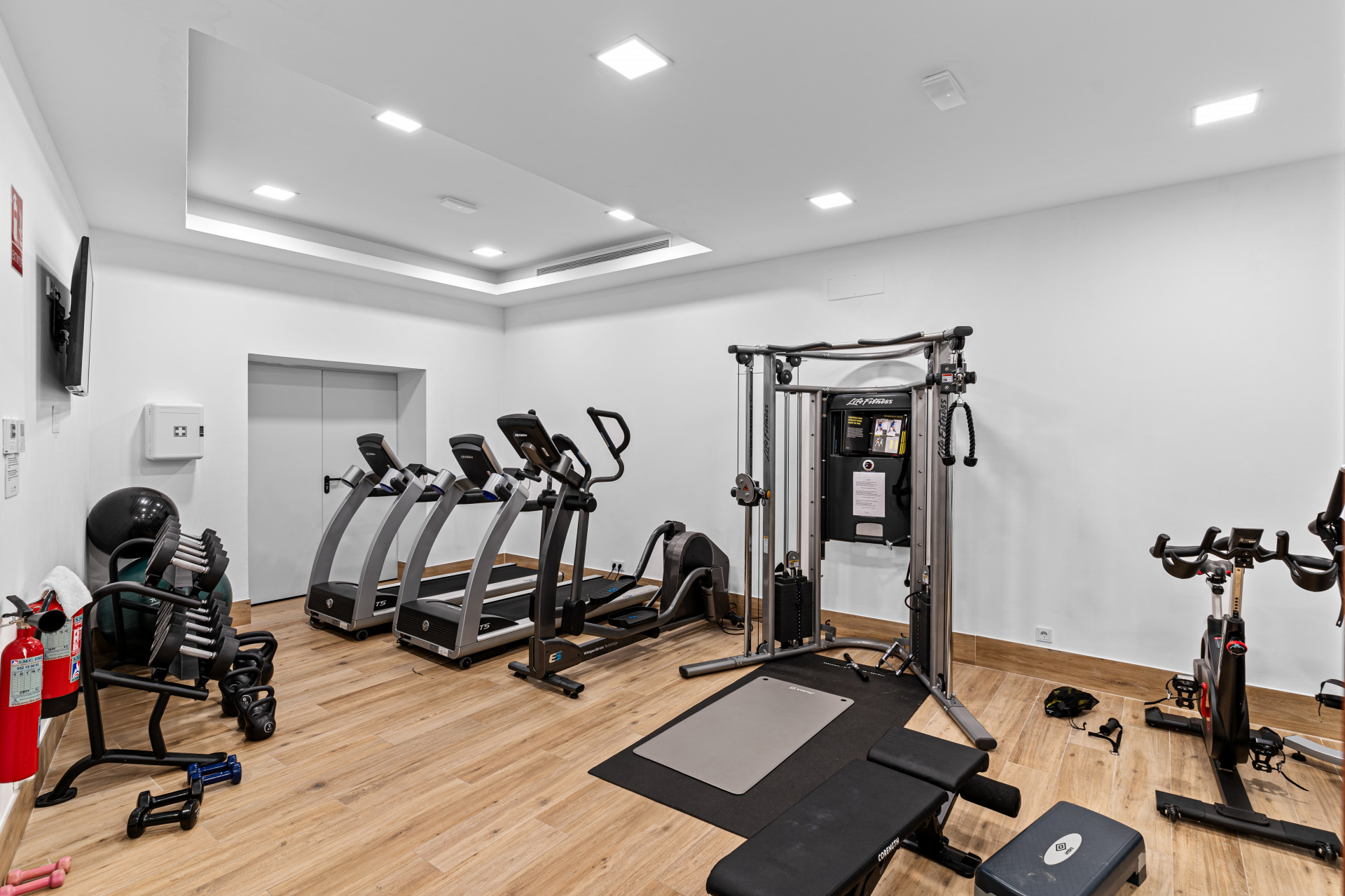 Home gym equipped with multiple exercise machines and free weights.
