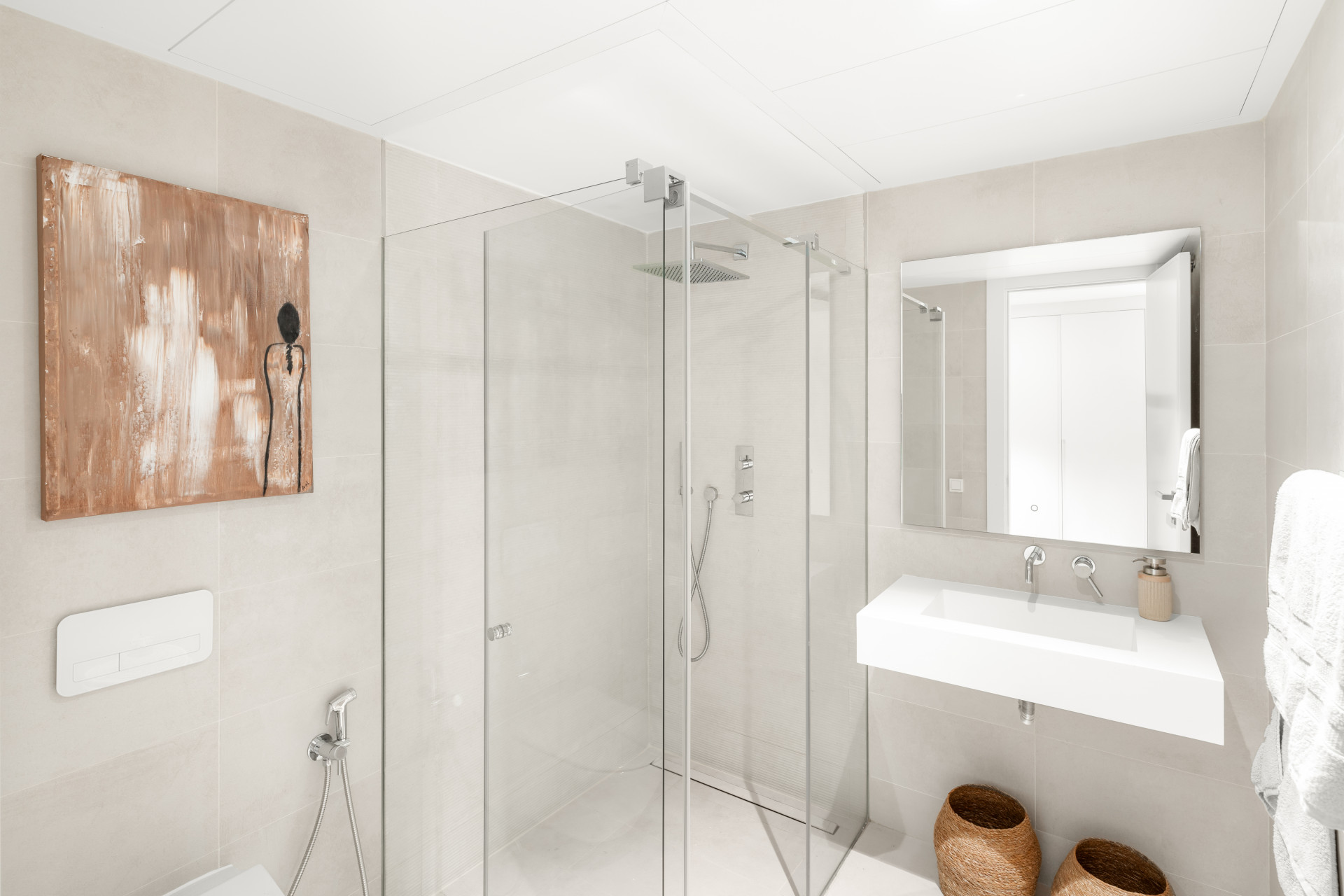 Bright bathroom featuring a large shower, minimalist sink, and modern decor.