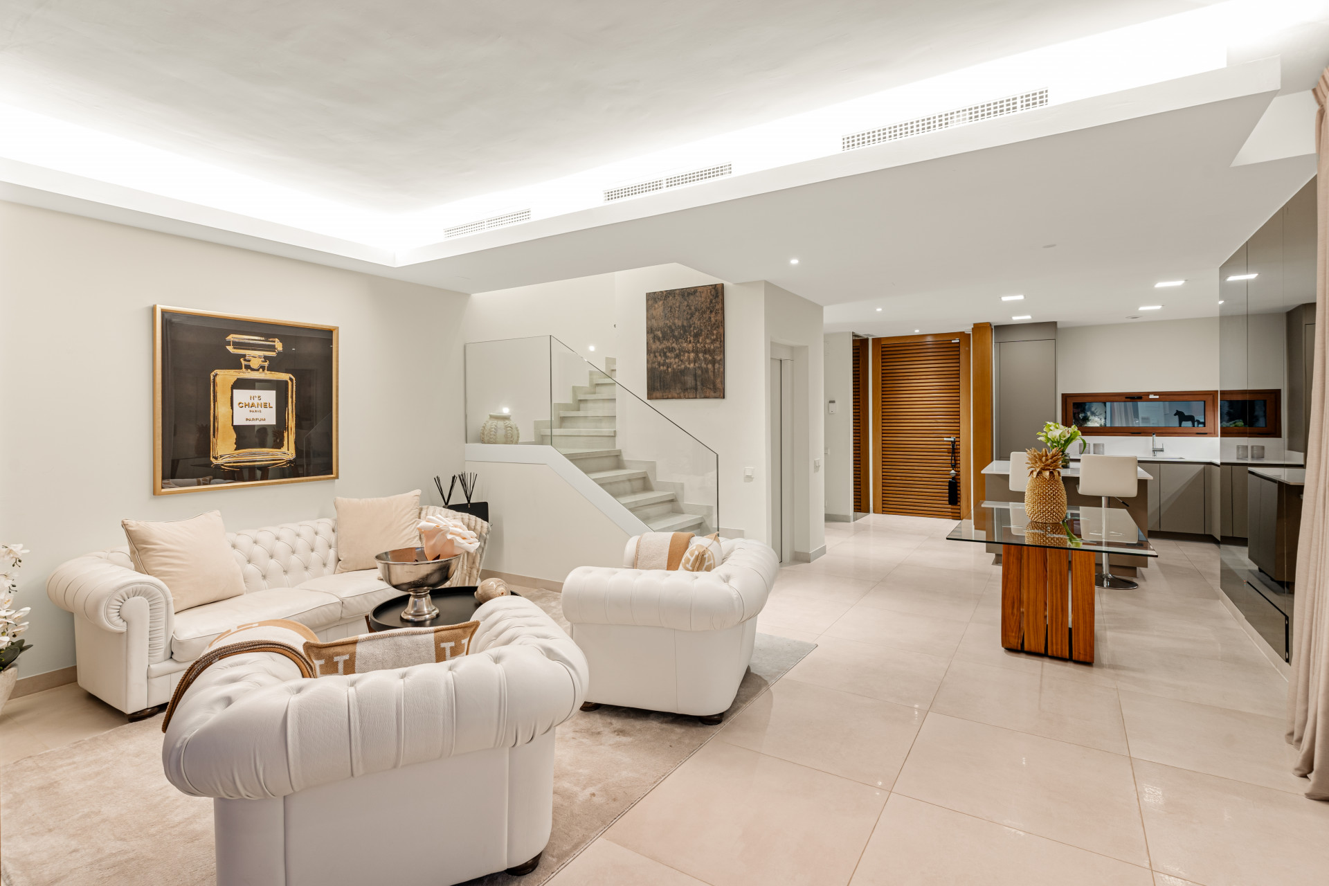 View of the living space, staircase and open kitchen area.