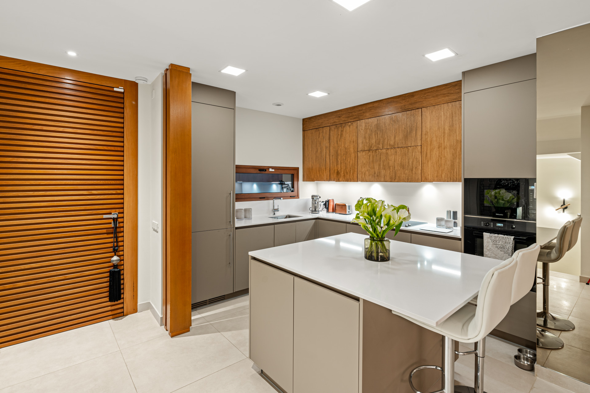 Kitchen entrance featuring wooden slat doors and bar seating.