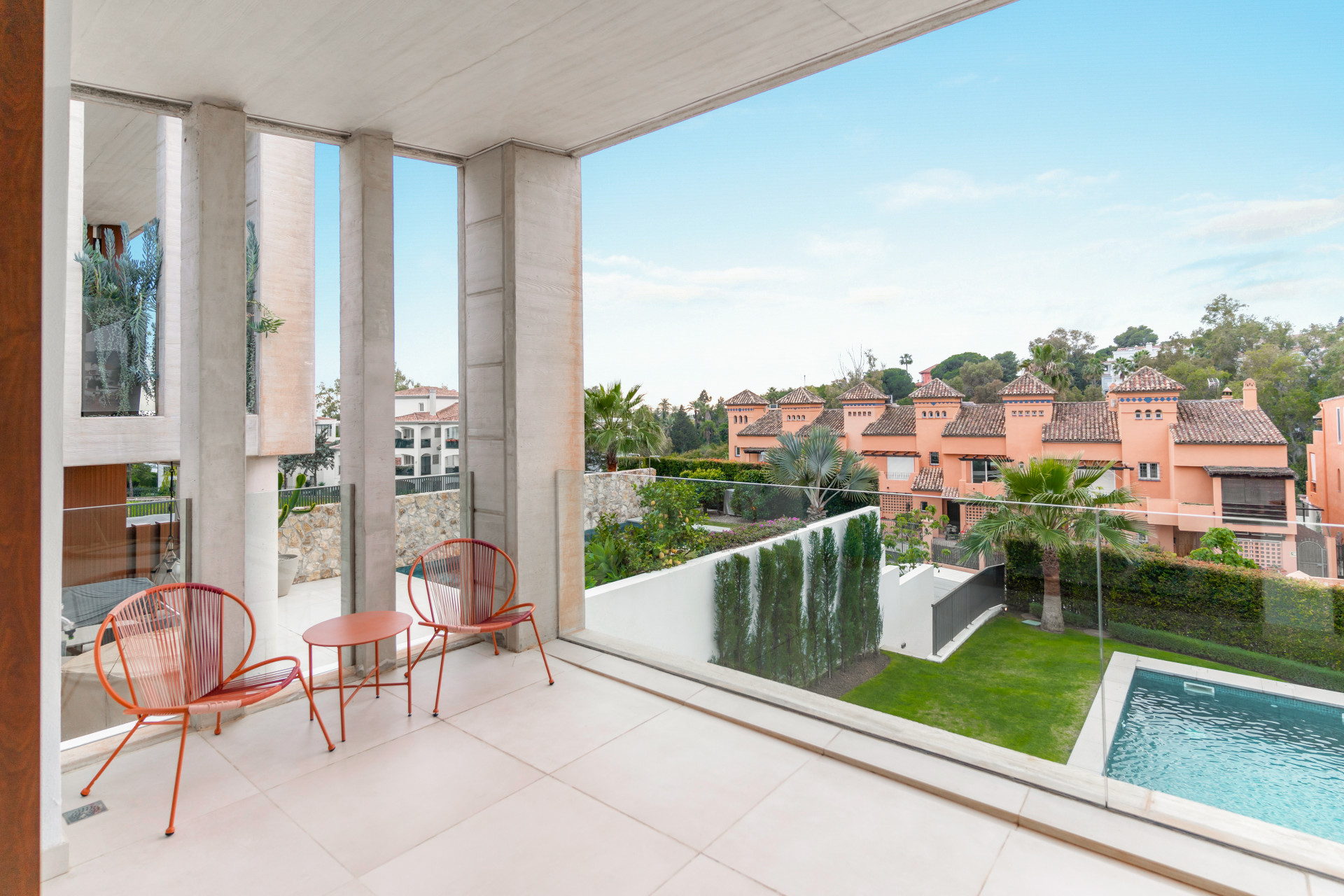 Covered terrace with stylish seating and views of landscaped gardens and swimming pool.