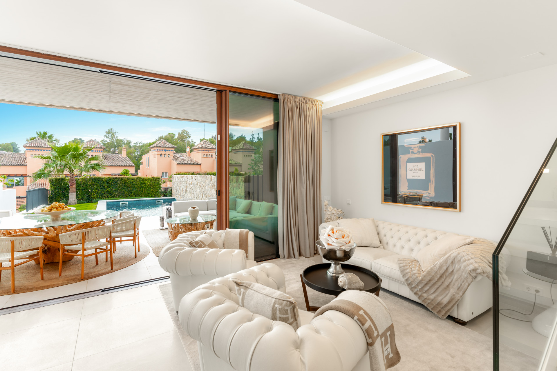 Lounge area showing tufted couches, artwork on the wall, and access to the outdoor space.