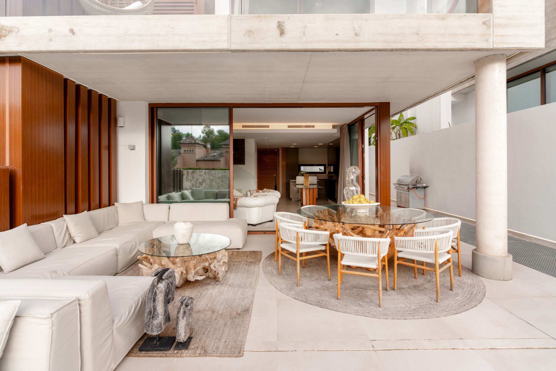 Covered terrace with stylish seating and a dining area overlooking the garden.