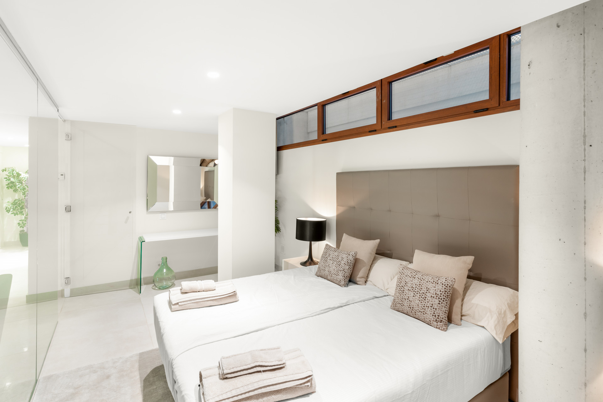 Bright room with two beds, modern decor, and an open vanity area.
