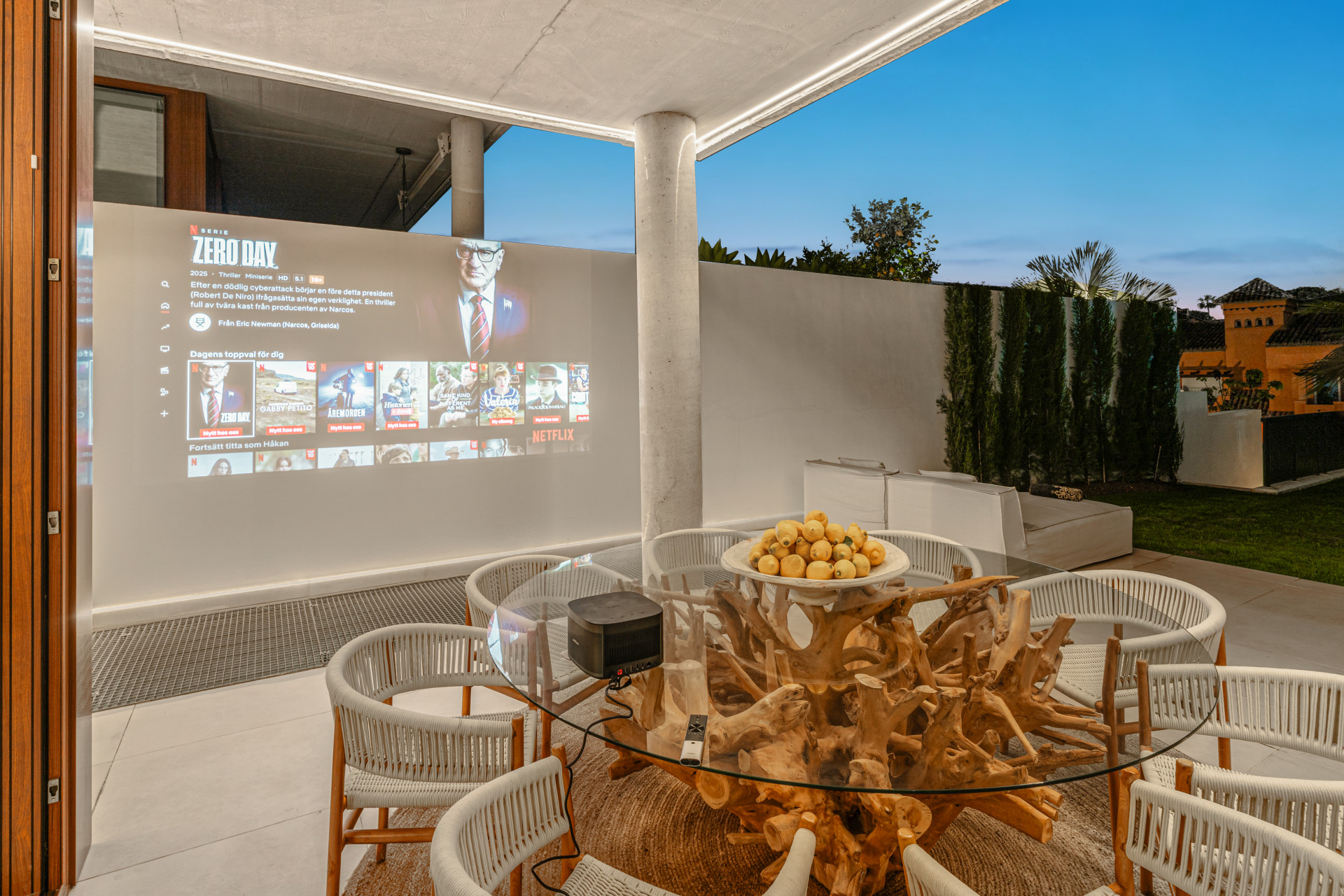Outdoor entertainment area featuring a projector screen and a rustic table.