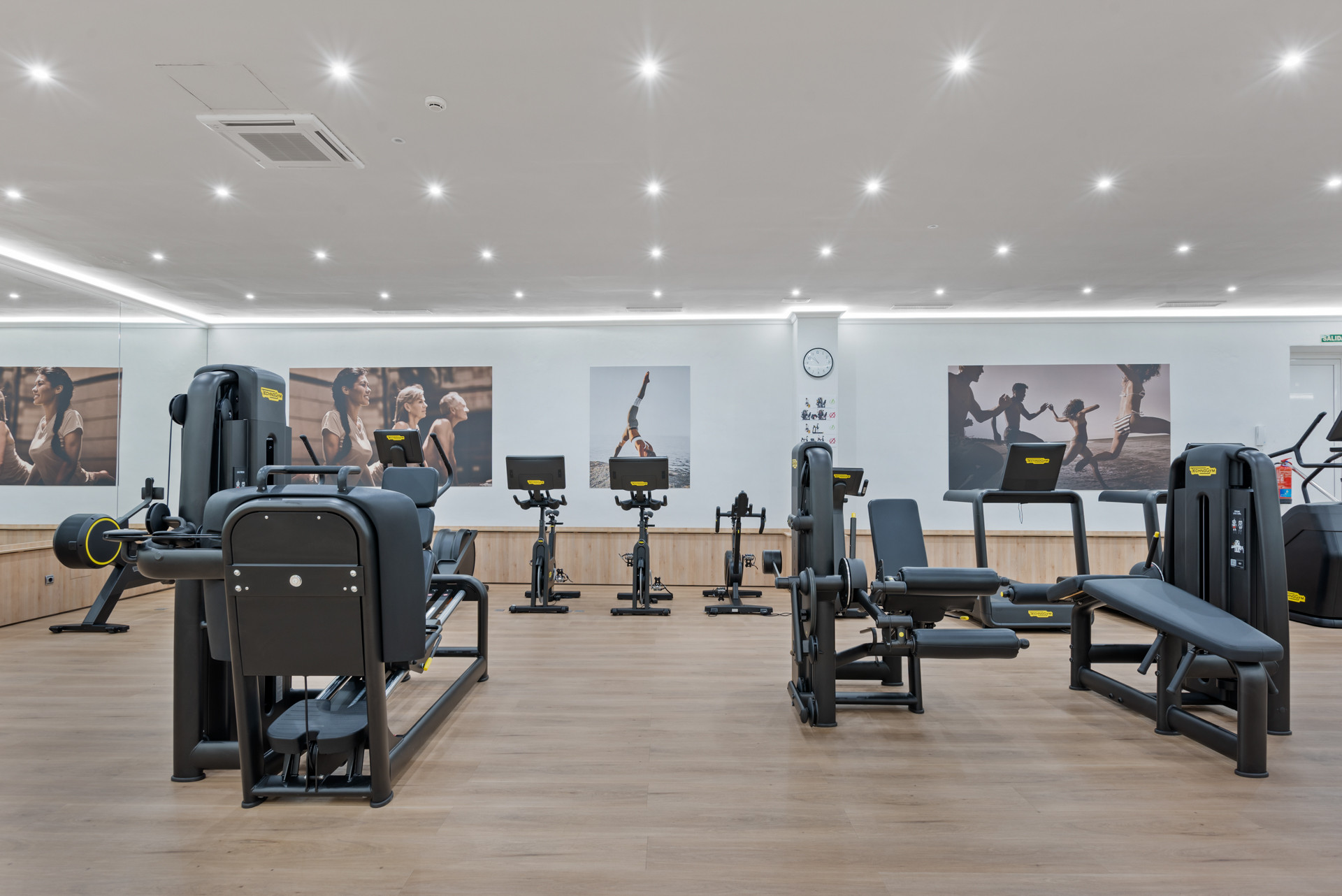 Modern gym with exercise equipment and motivational wall art.