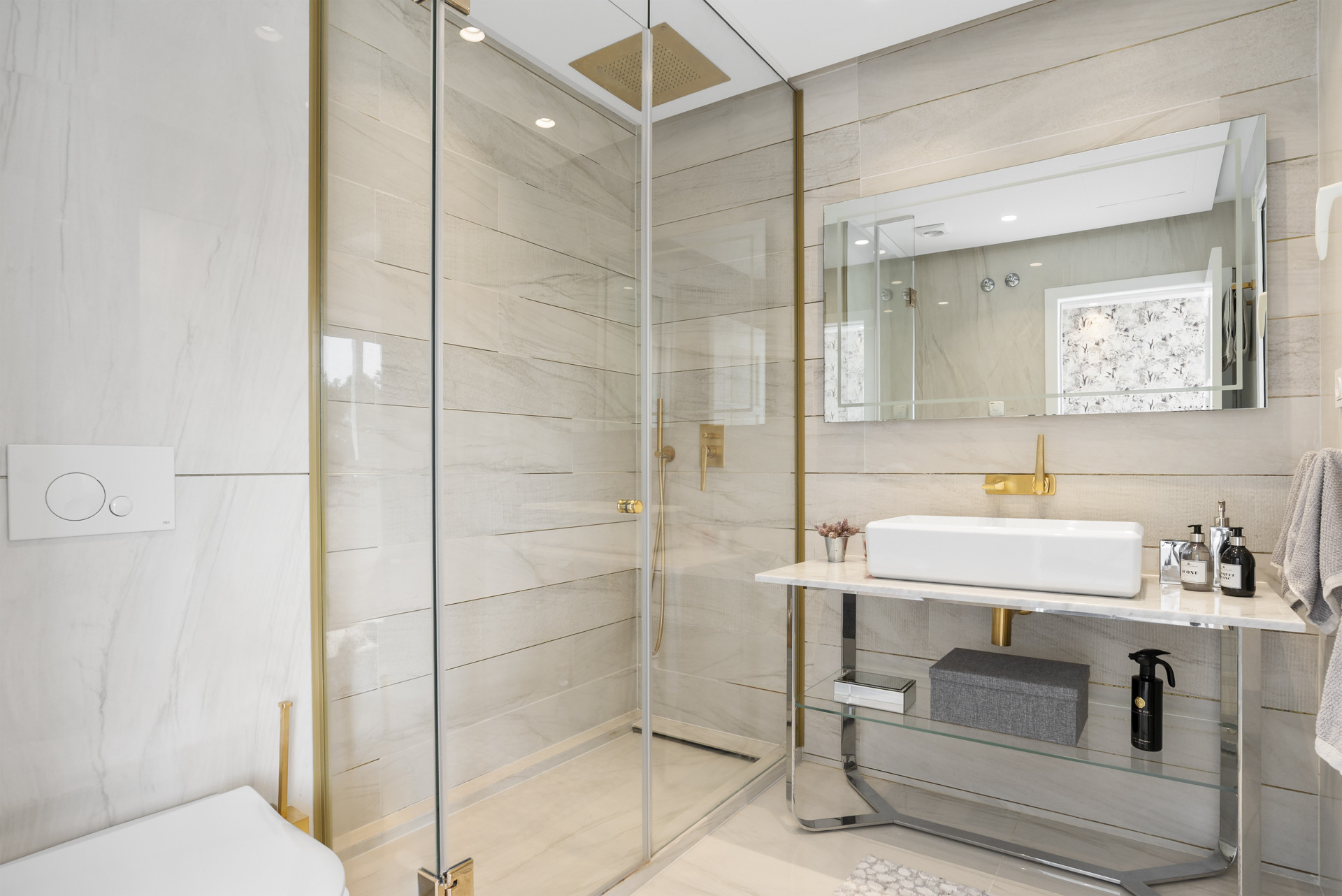 Modern bathroom with glass shower, stone tiles, and elegant fixtures.