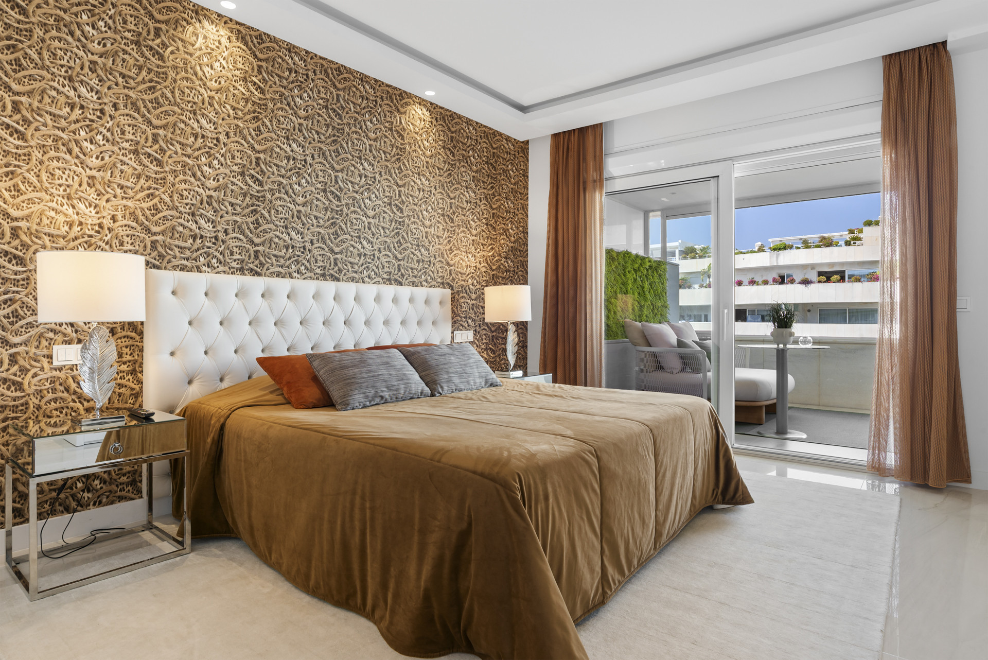 Spacious bedroom with textured wall, balcony access, and stylish bedside table.