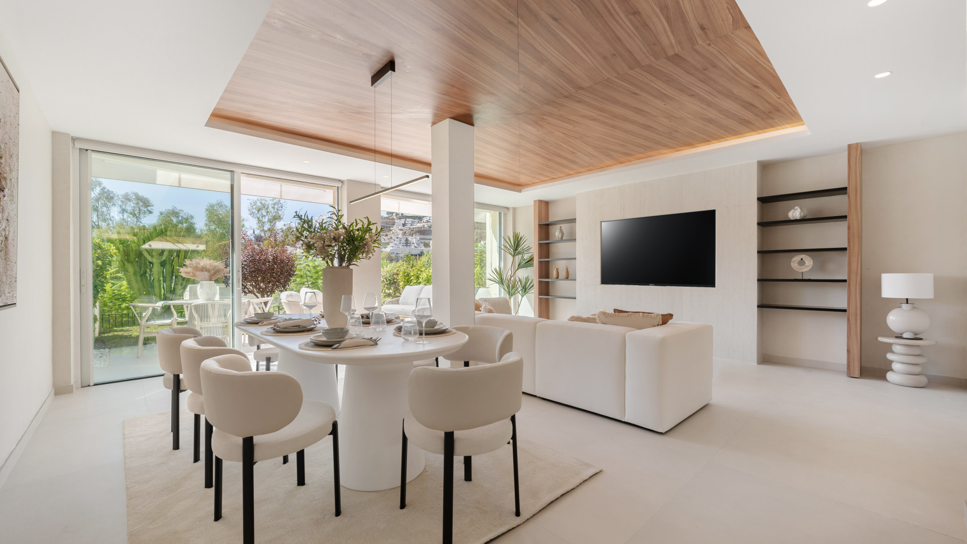 Dining area featuring a round table with chairs and large sliding glass doors to the garden.