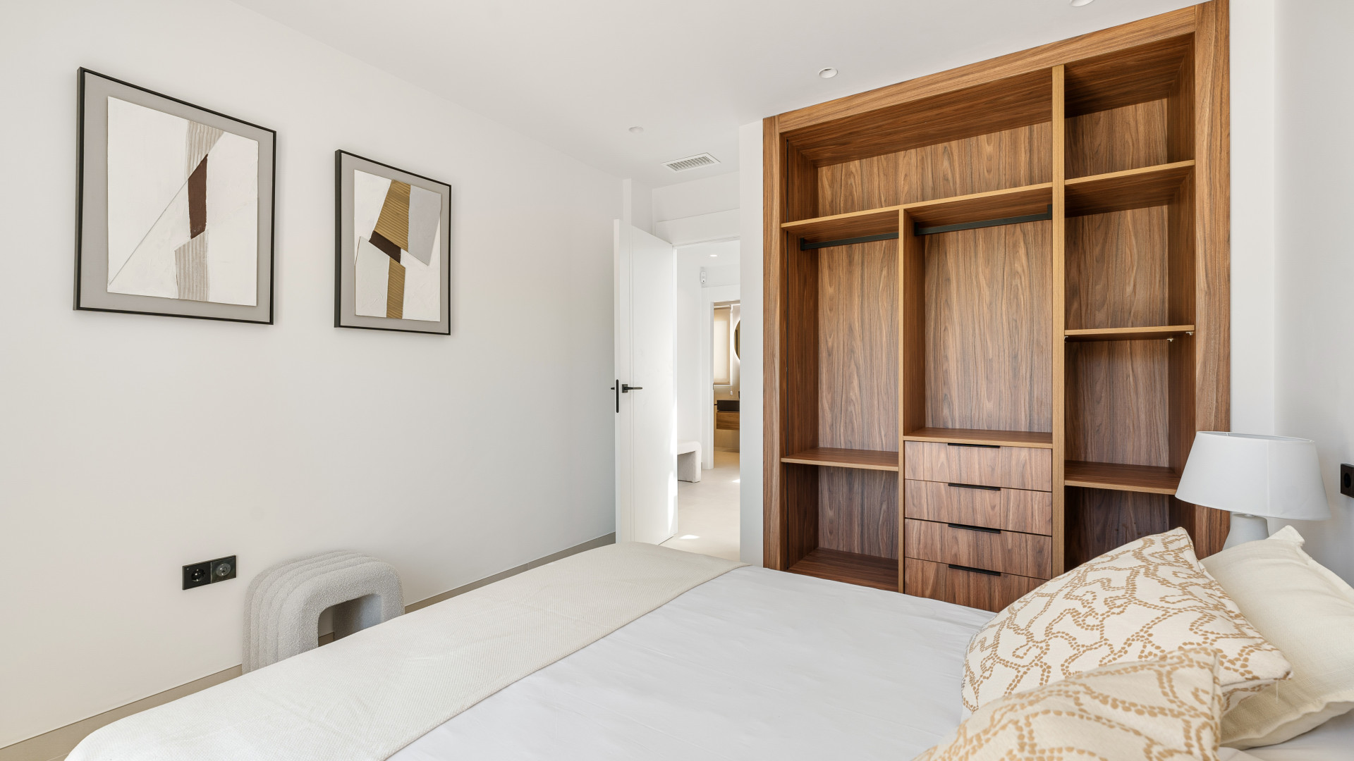 Cozy bedroom featuring a wooden closet and framed artwork on the walls.