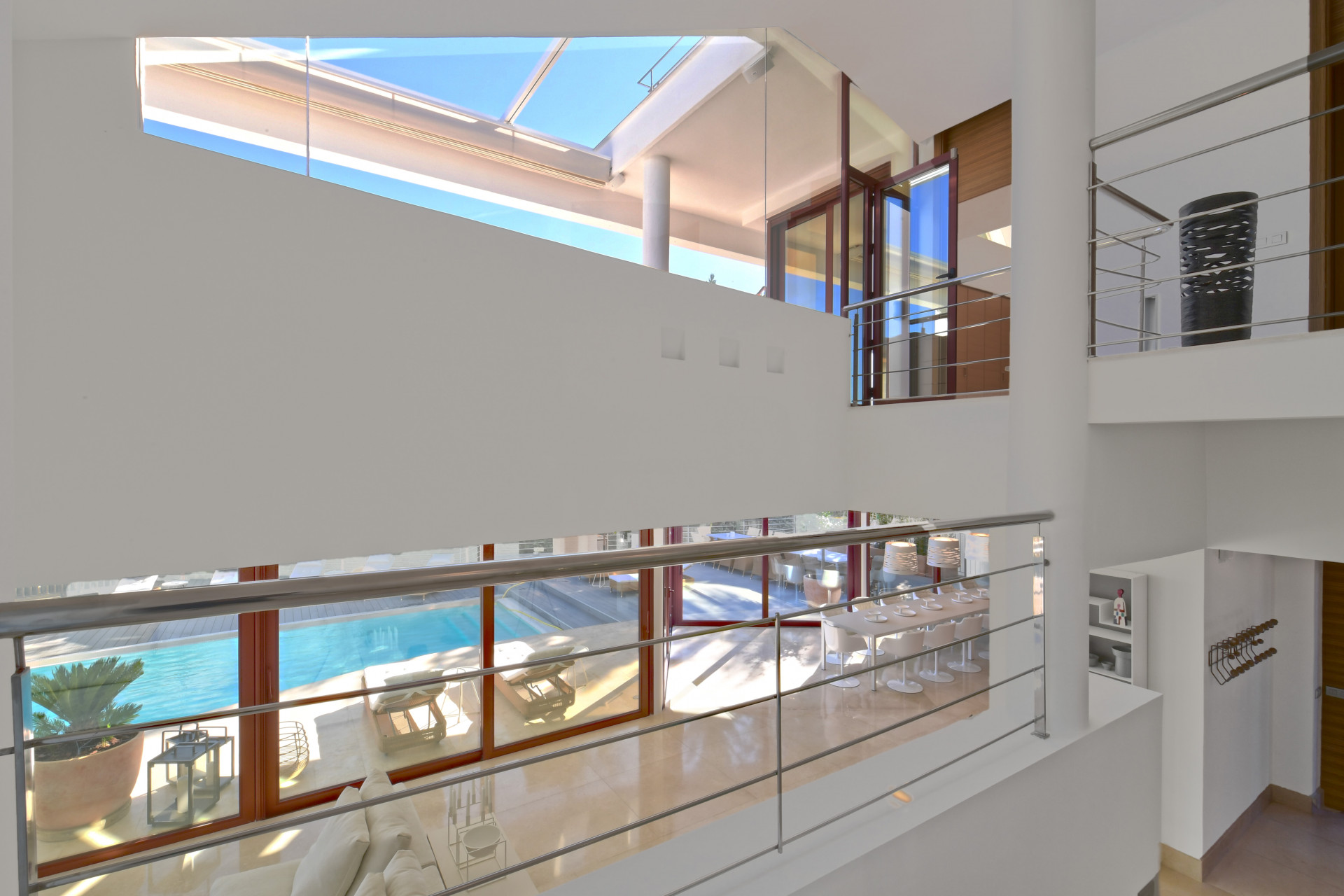 Interior view showing a spacious area with glass railings and large windows overlooking the pool.