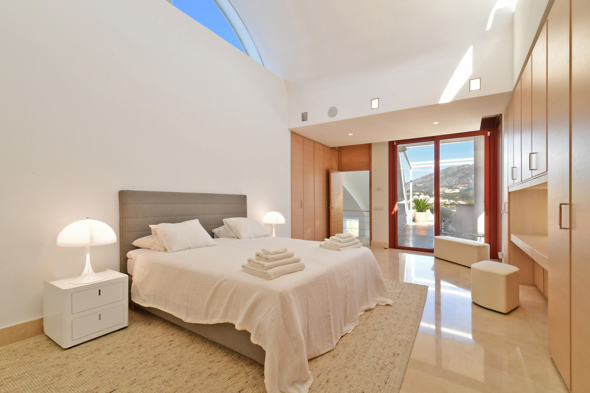 Second bedroom with modern furnishings, natural light from large window, and a structured ceiling design.