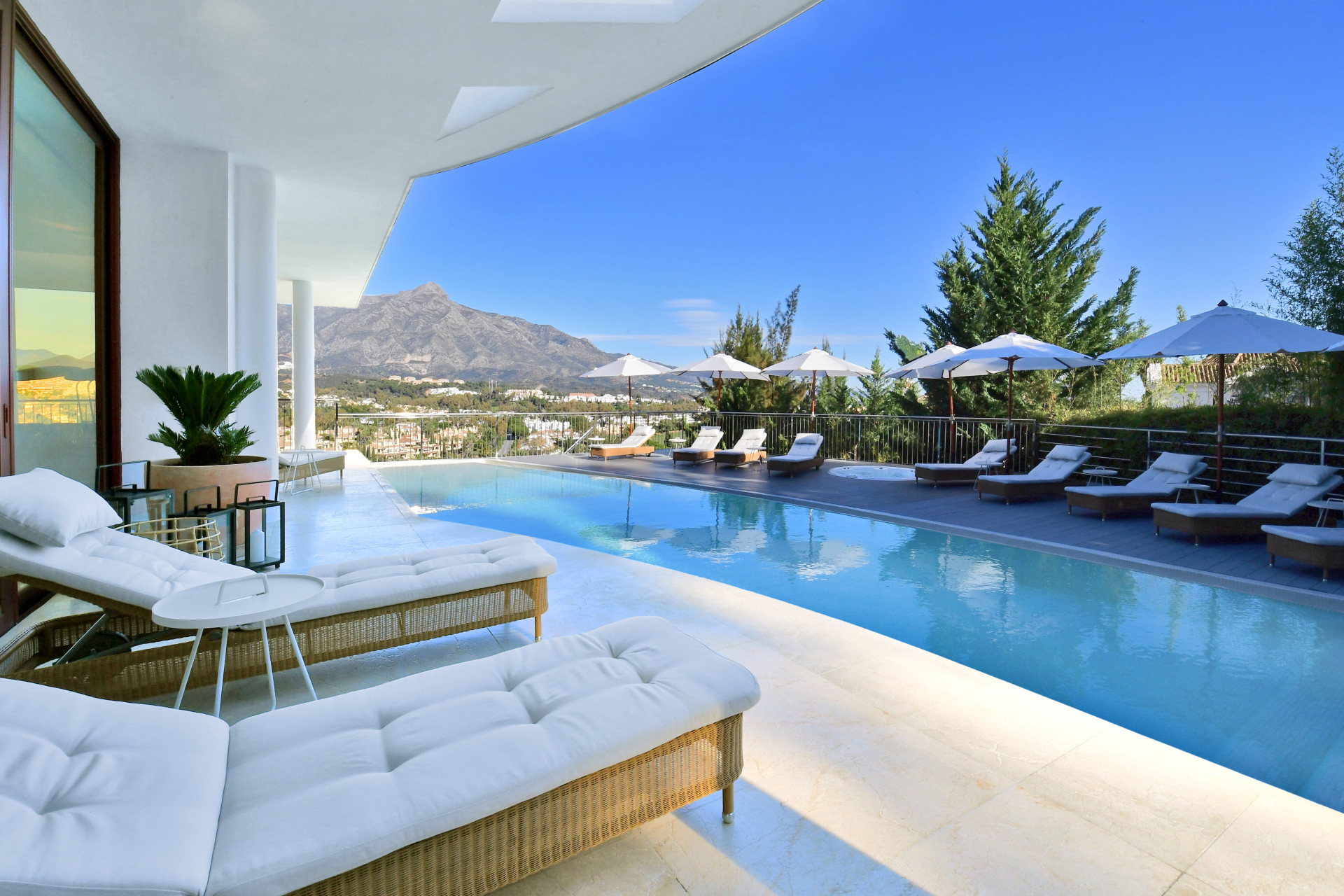 Poolside seating area with lounge chairs and umbrellas