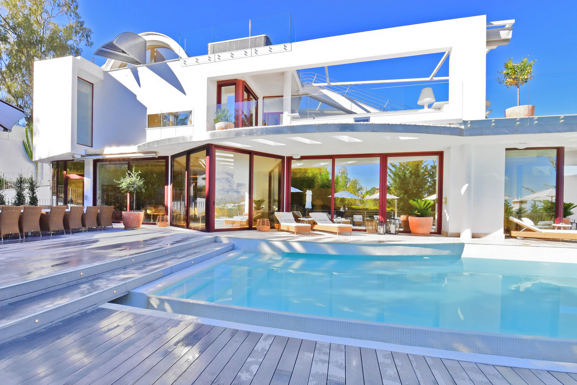 Focus on the pool area with a dining space and steps leading to the water.