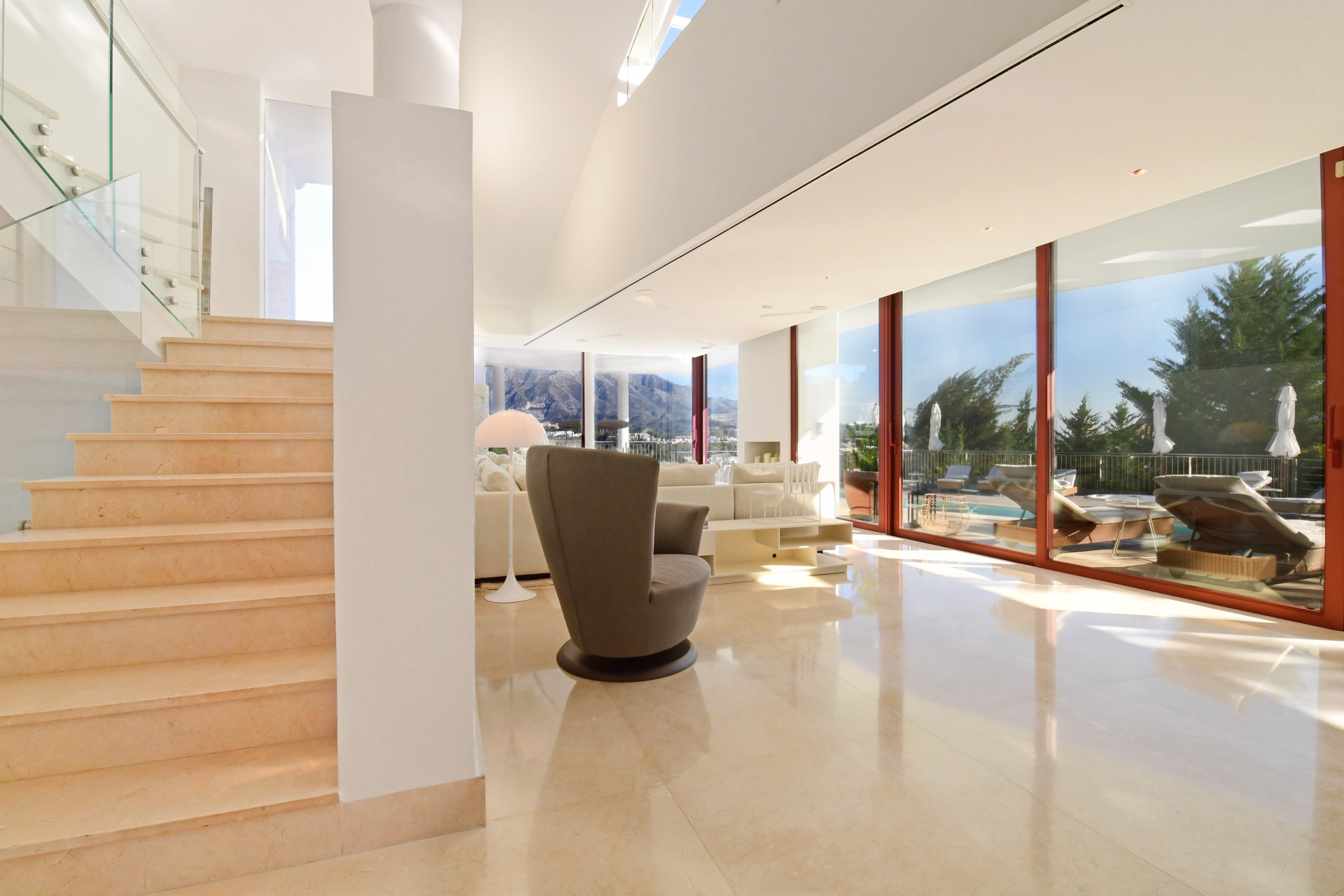 Staircase leading to living area with large windows displaying a mountain view