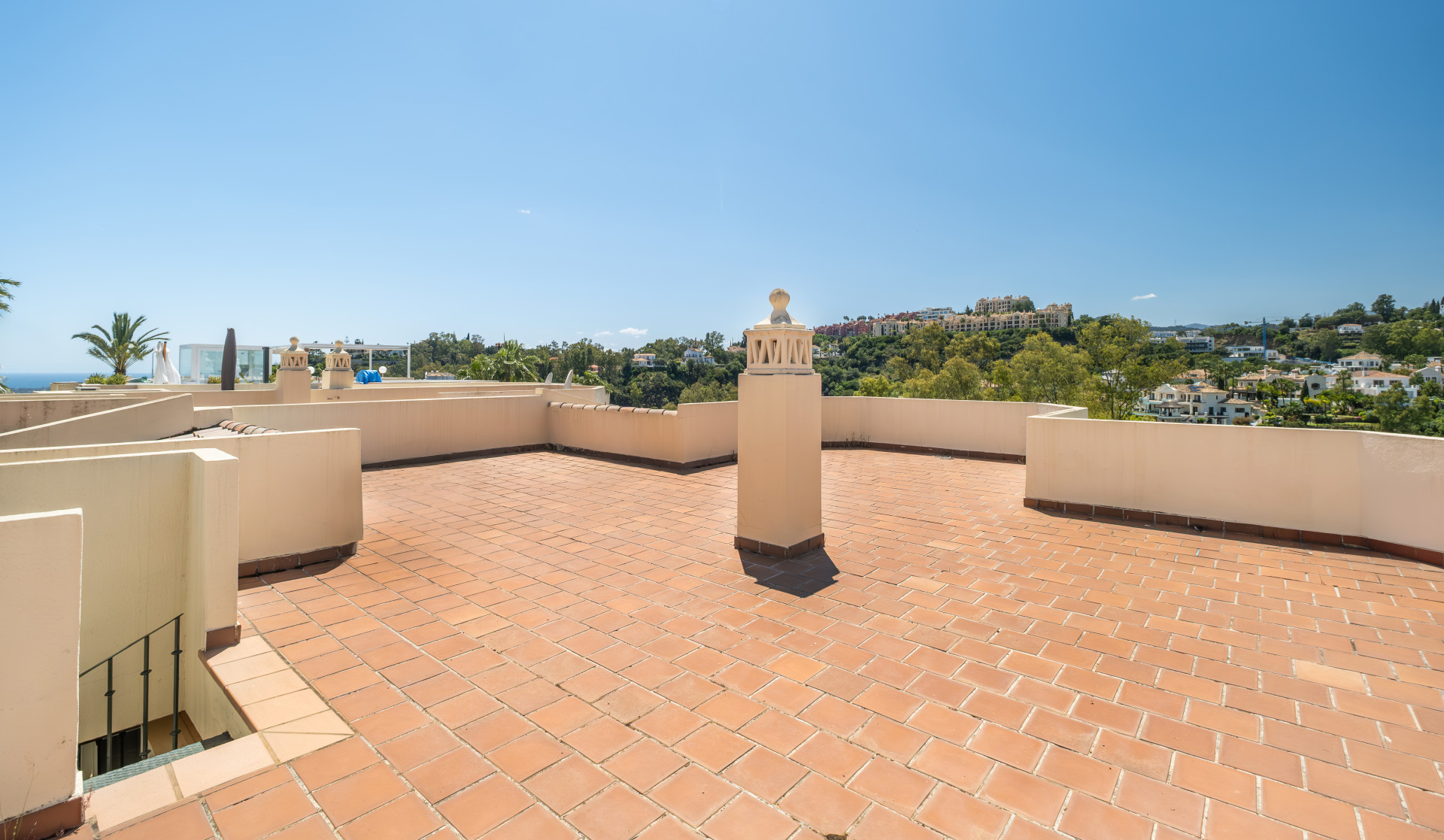 Large terrace with terracotta flooring and a panoramic view of the landscape.