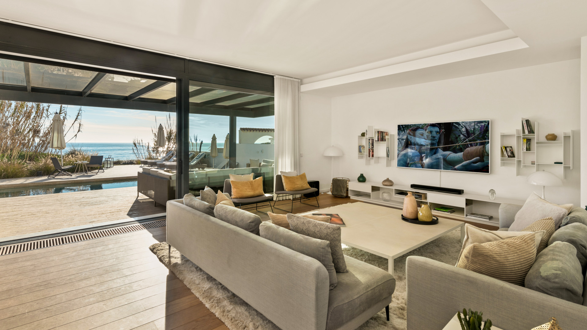 Cozy living room with a plush sofa and home entertainment setup overlooking the outdoor terrace.