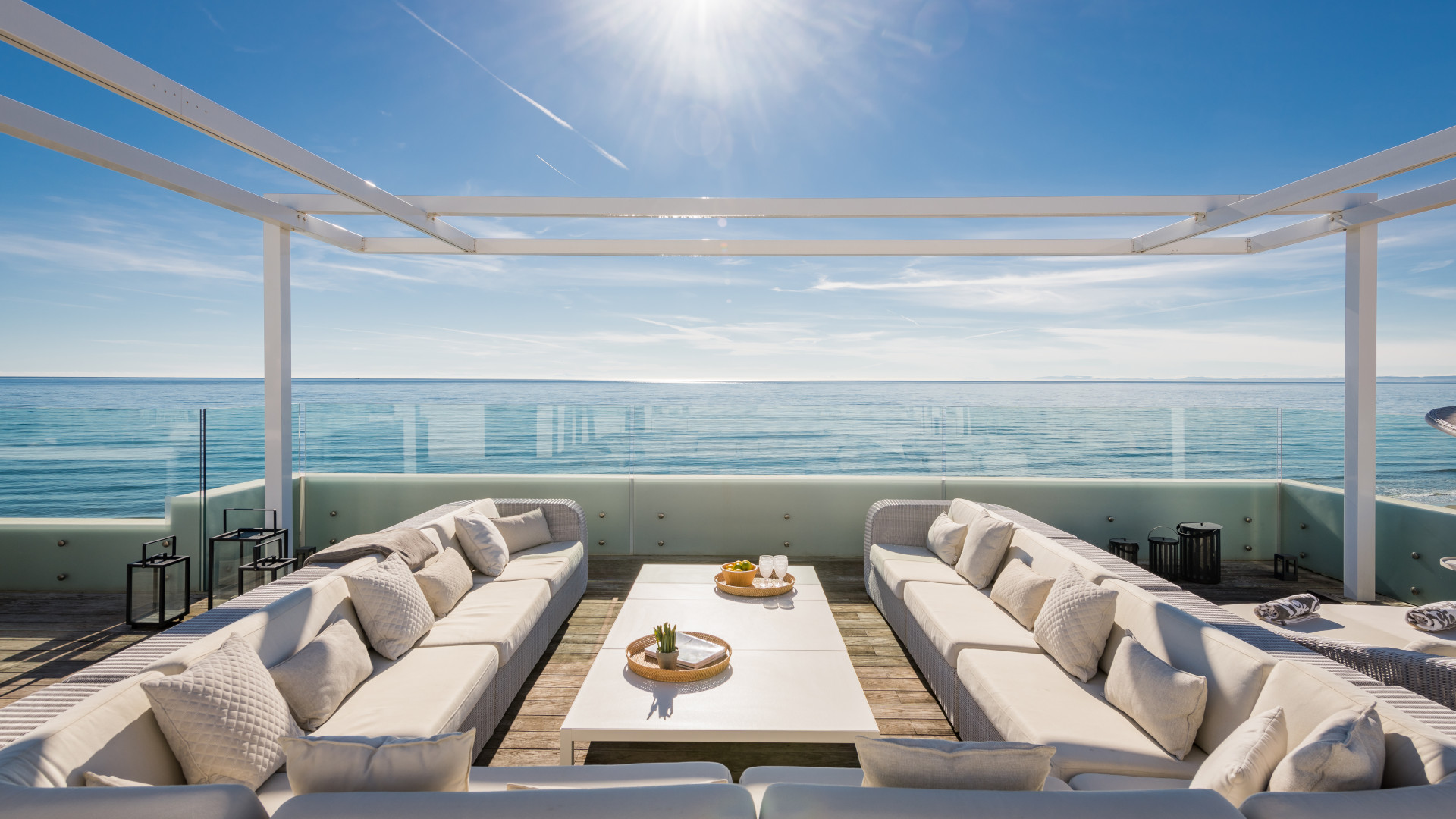 Bright terrace with lounge seating and ocean in background.
