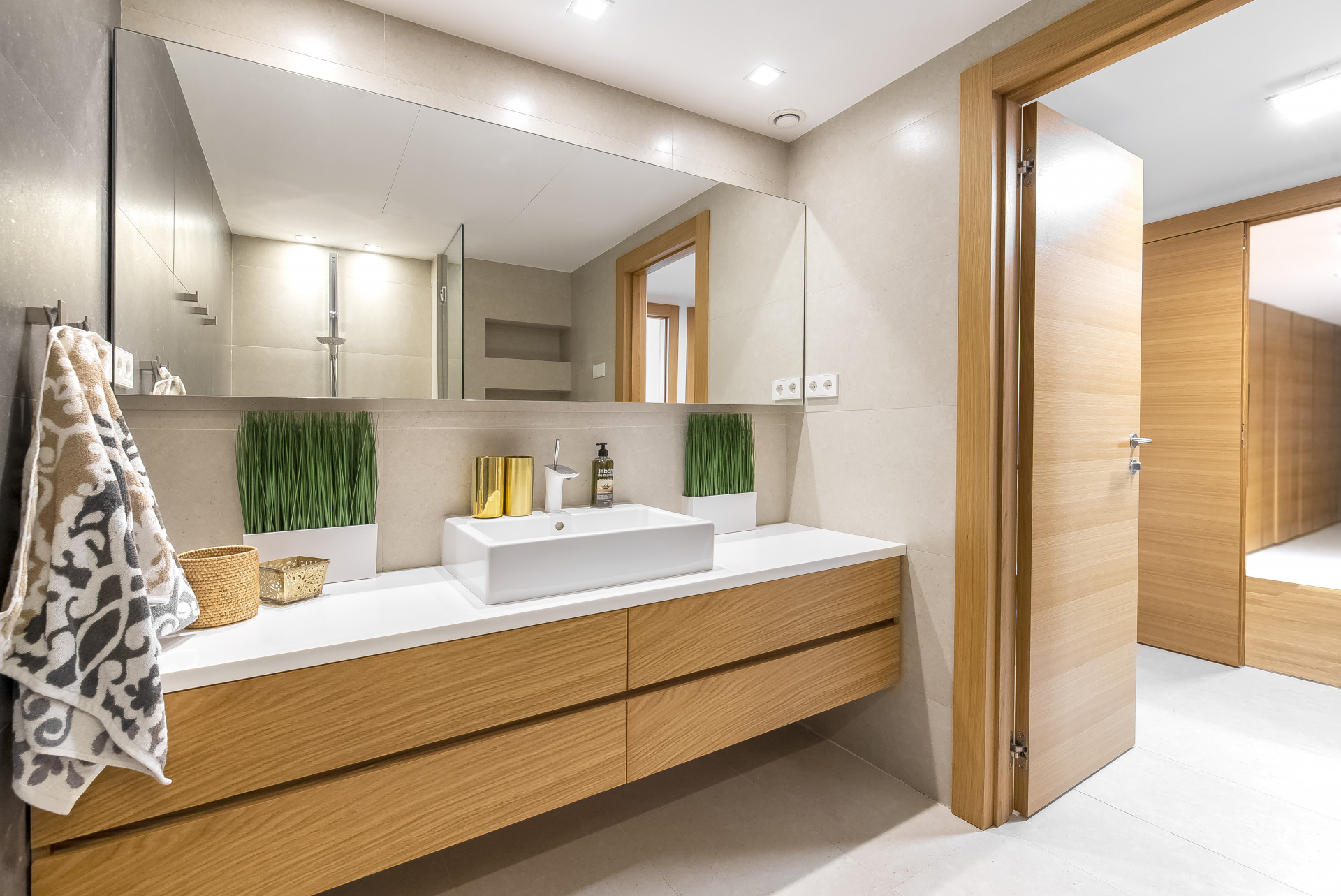 Contemporary bathroom featuring a modern sink, mirror, and wooden storage cabinet.