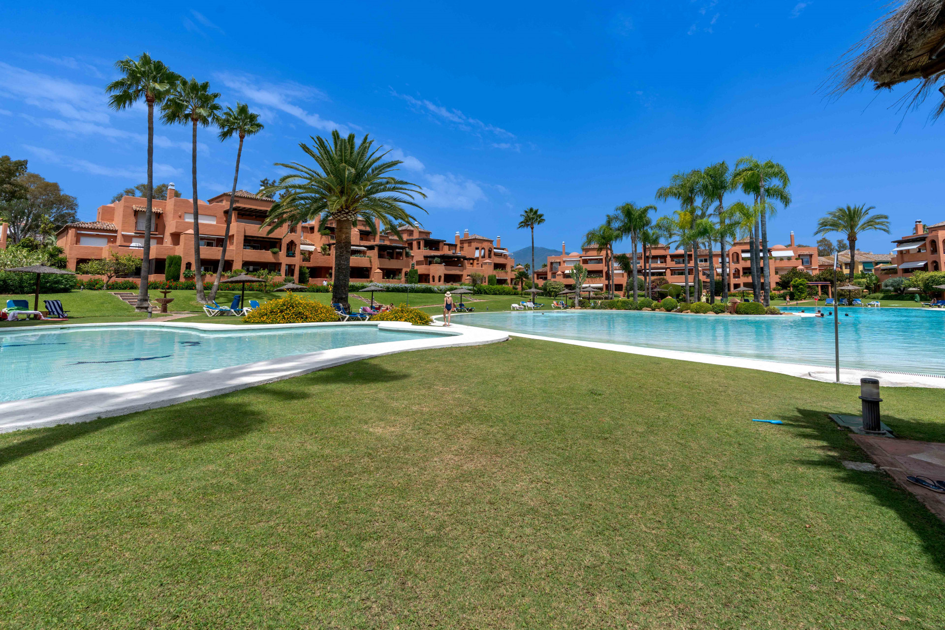 Elegant 3-bedroom first-floor apartment in prestigious Guadalmina Baja, just minutes from the beach. Spacious interiors, 55 m² terrace, stunning gardens, and lagoon-style pool in a secure community.