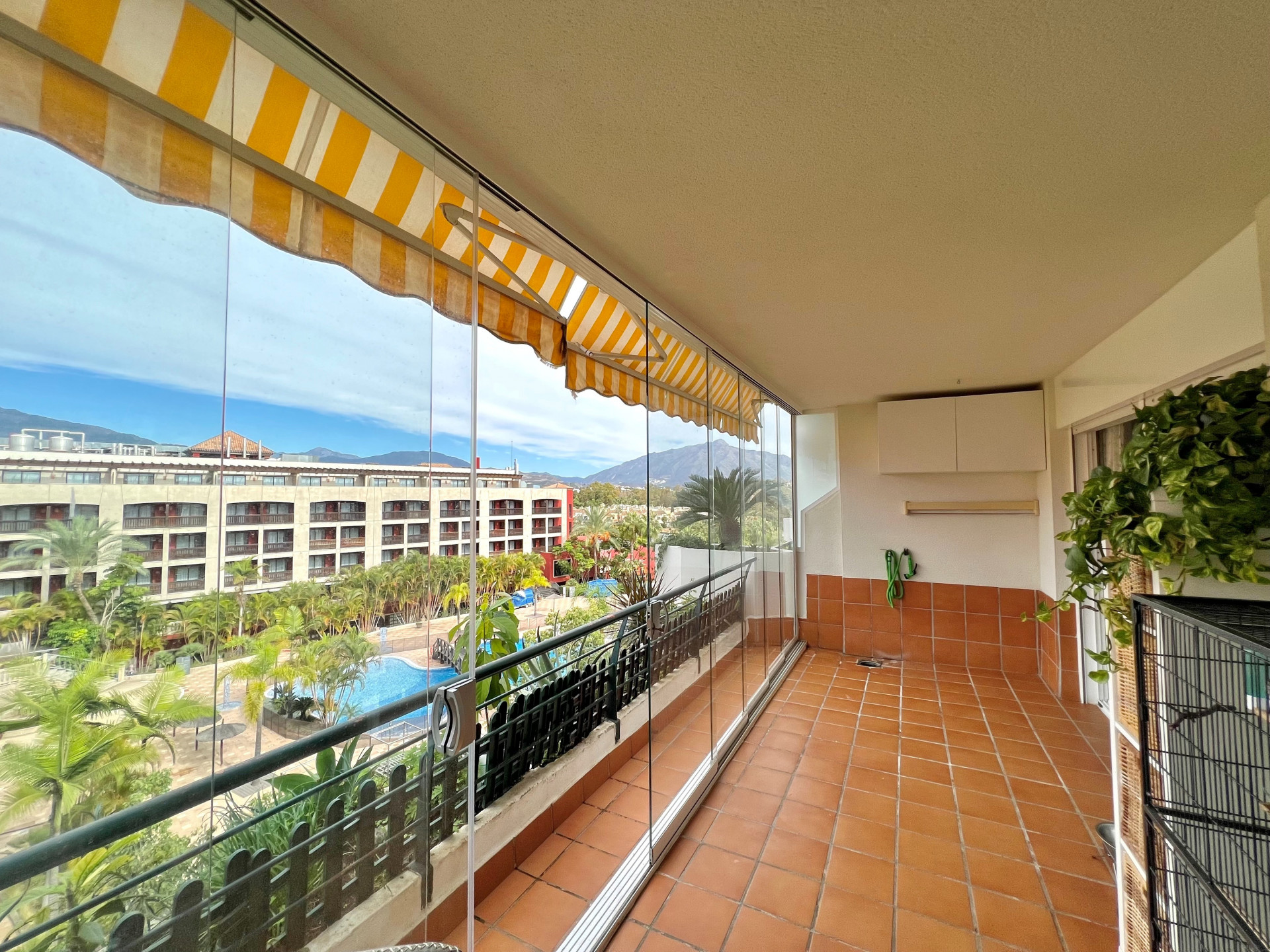 Apartamento en última planta con una amplia terraza acristalada que disfruta del sol de la tarde en Campos de Guadalmina