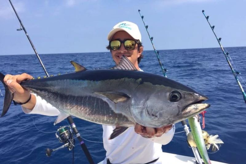 man holding his catch of the day, deep-sea fishing is one of the water sports and activities in Marbella