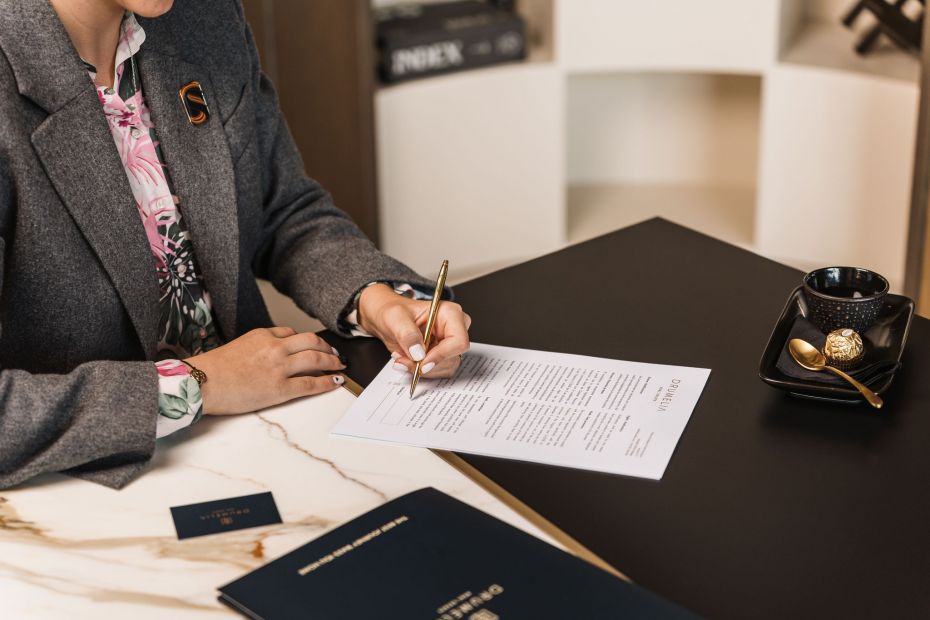 Fotografía de un agente inmobiliario de Drumelia firmando un contrato en Marbella 