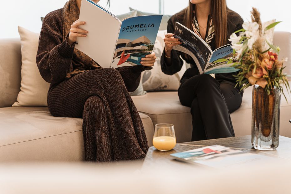 Photograph of people reading the Drumelia Magazine in the Drumelia Office