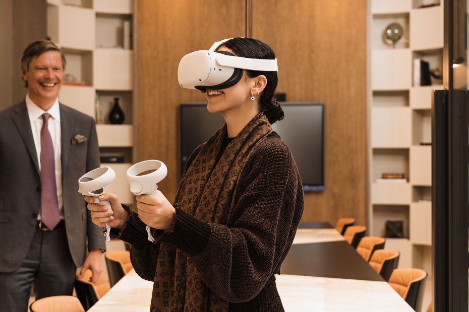 Photo d'une personne utilisant le casque VR de Drumelia dans le bureau avec un agent montrant une propriété virtuellement.