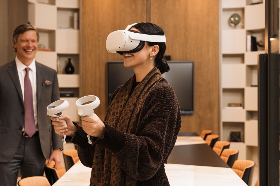 Photograph of someone using Drumelia's VR headset in the office with an agent showing a property virtually.