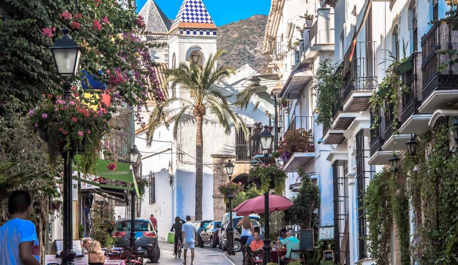 Foto der Altstadt von Marbella an einem sonnigen Tag mit Menschen auf der Straße. 