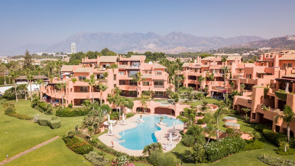 View of La Morera beachfront luxury development with pool and mountains behind in Los Monteros beach, Marbella, Costa del Sol, Málaga