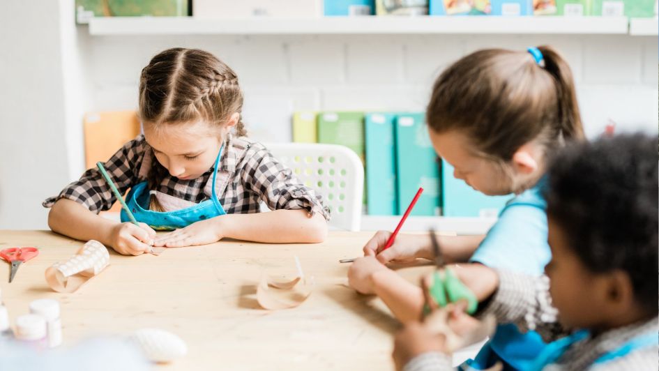 Jeunes enfants faisant de l'artisanat dans un environnement scolaire