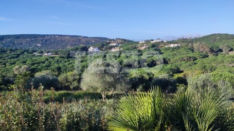 Elevated plot in Sotogrande Alto with panoramic views of the golf course and lake, featuring an approved contemporary project and ready to build.